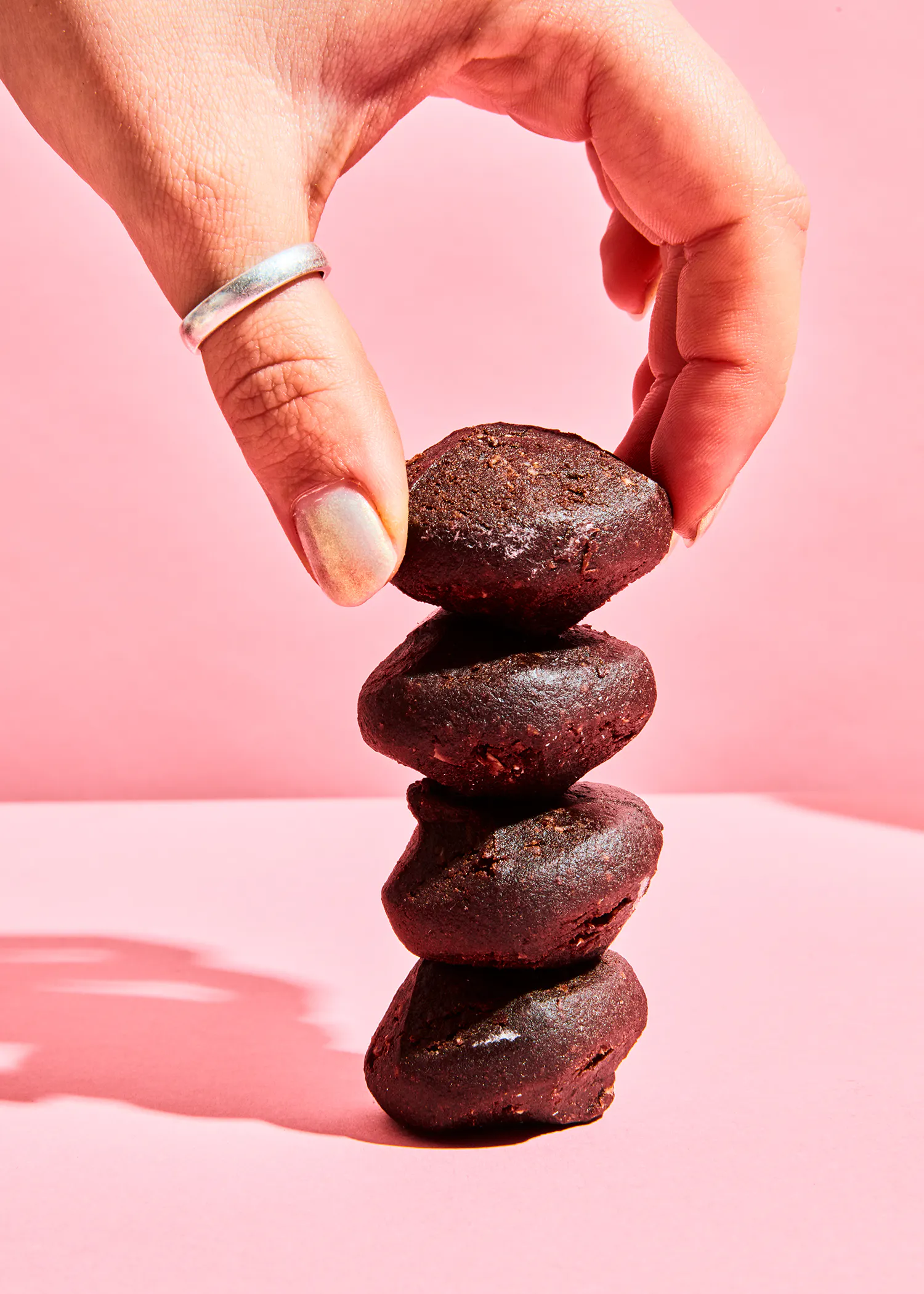 a person stacking a stack of chocolate cookies on top of each other