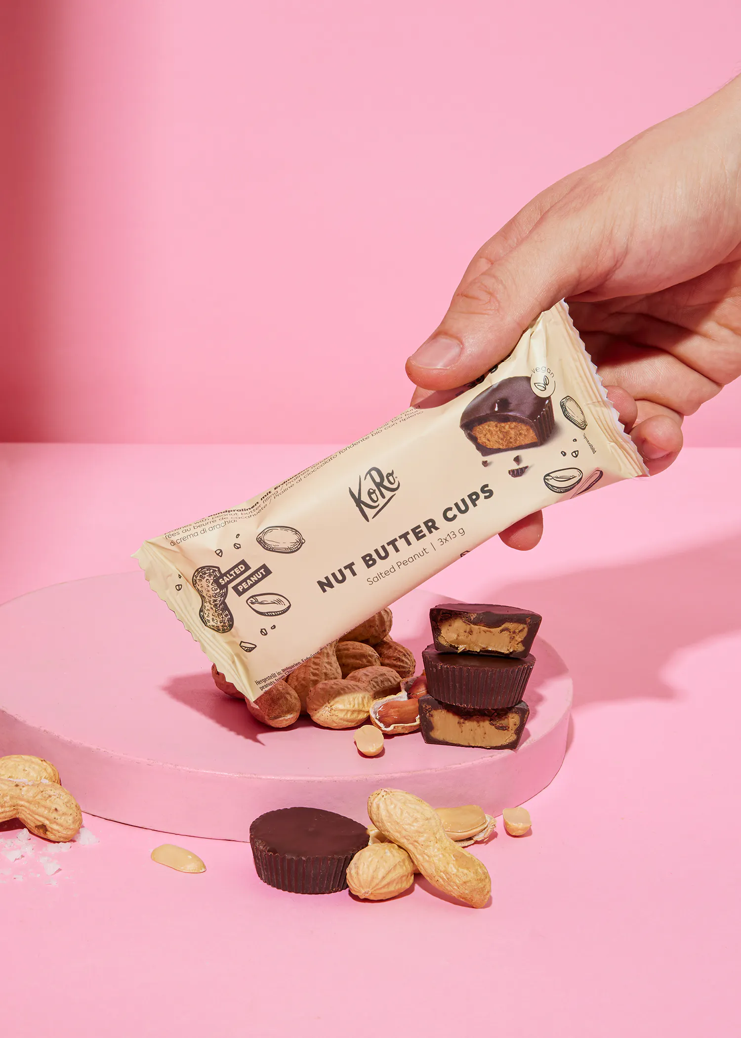 une personne tient un paquet de tasses au beurre de cacahuètes