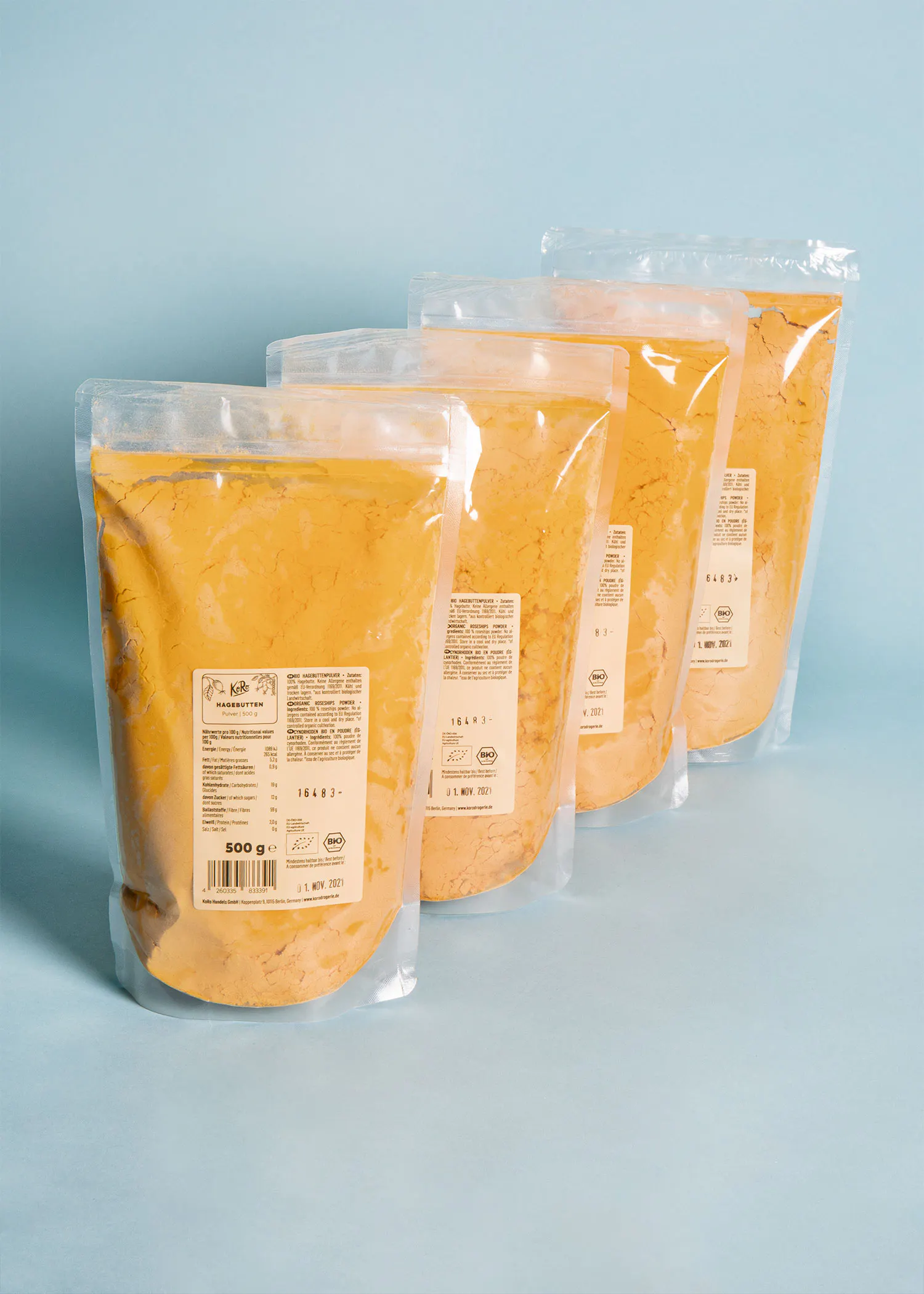 four bags of powder are lined up on a blue background