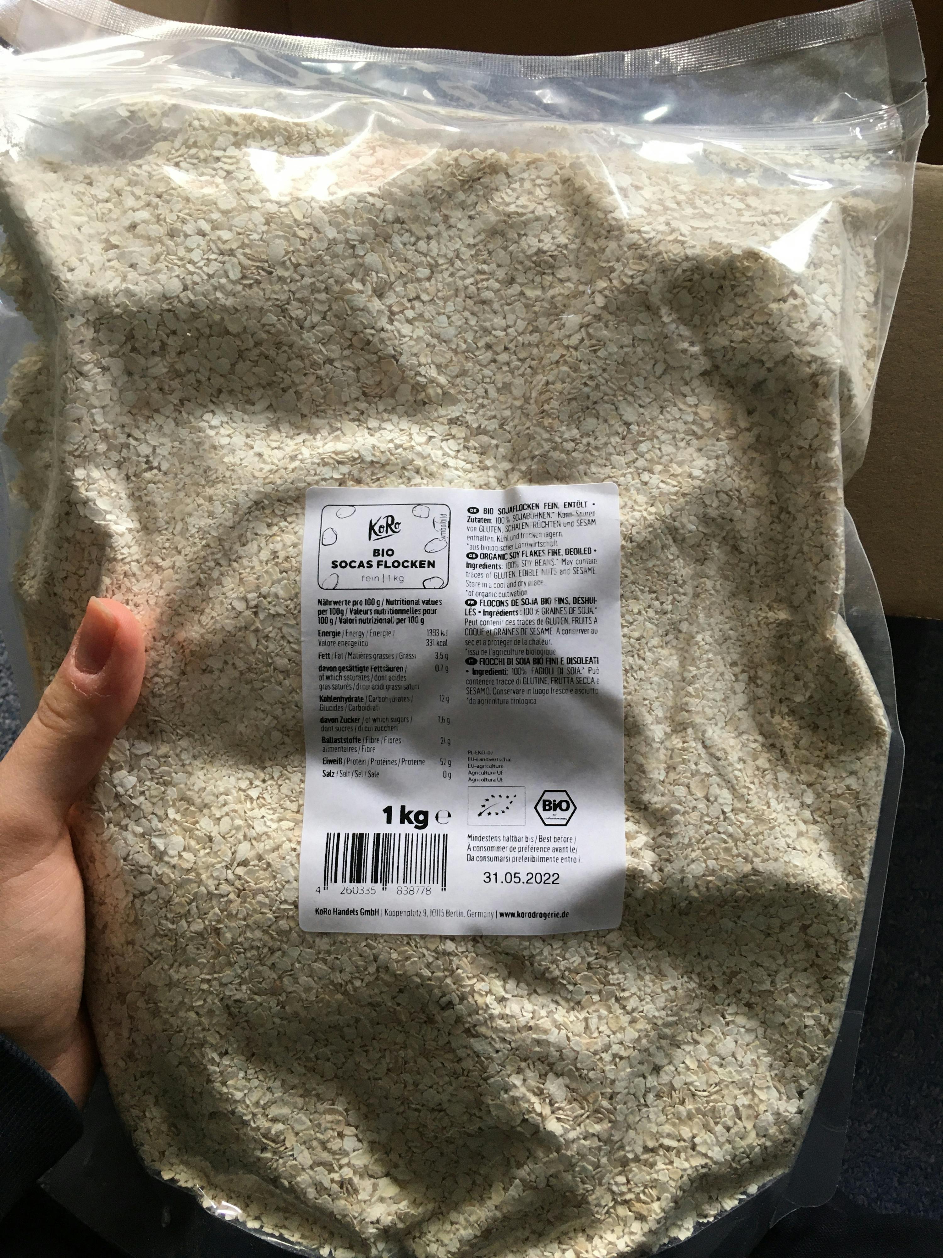 une personne tient un sac de flocons d' avoine de 1kg