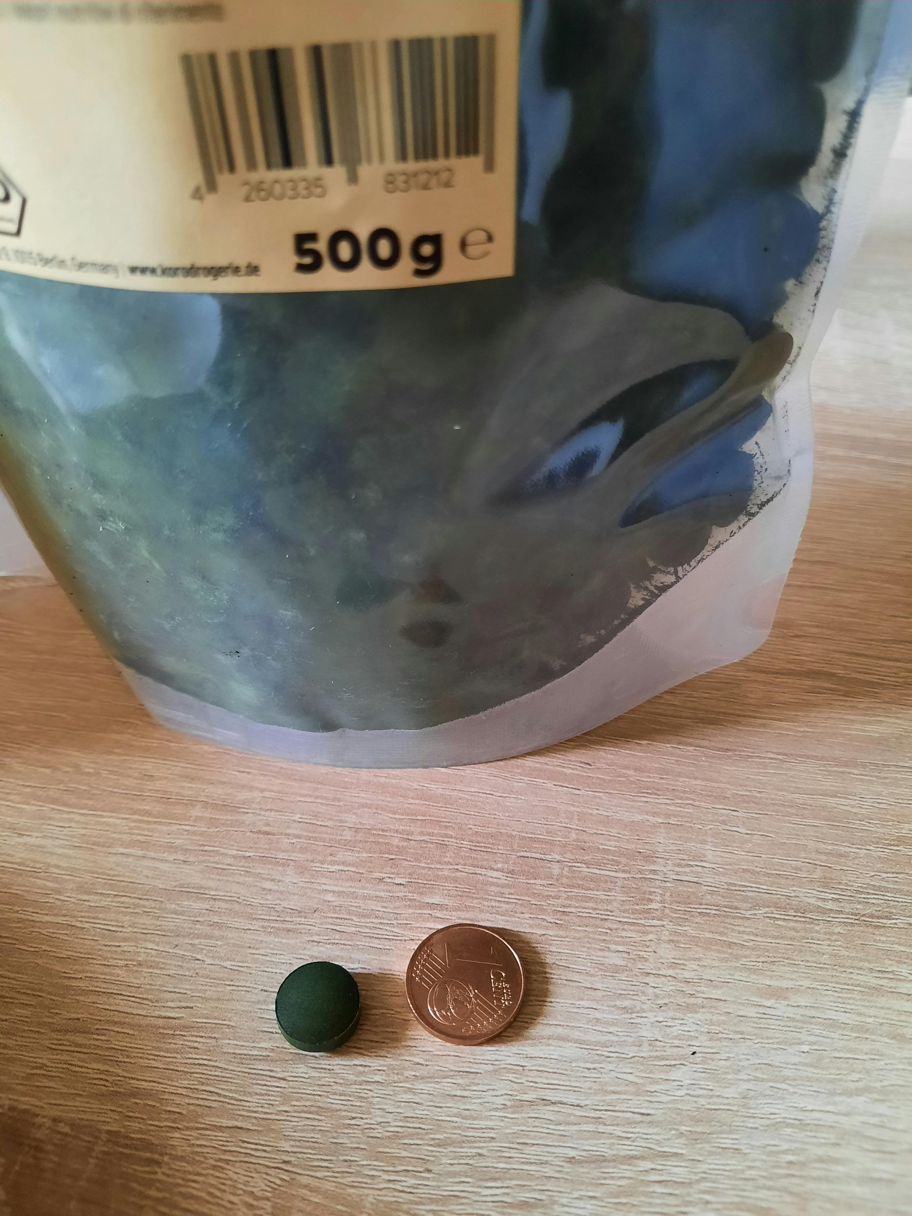 une pièce de monnaie est posée à côté d' un sac de 500g