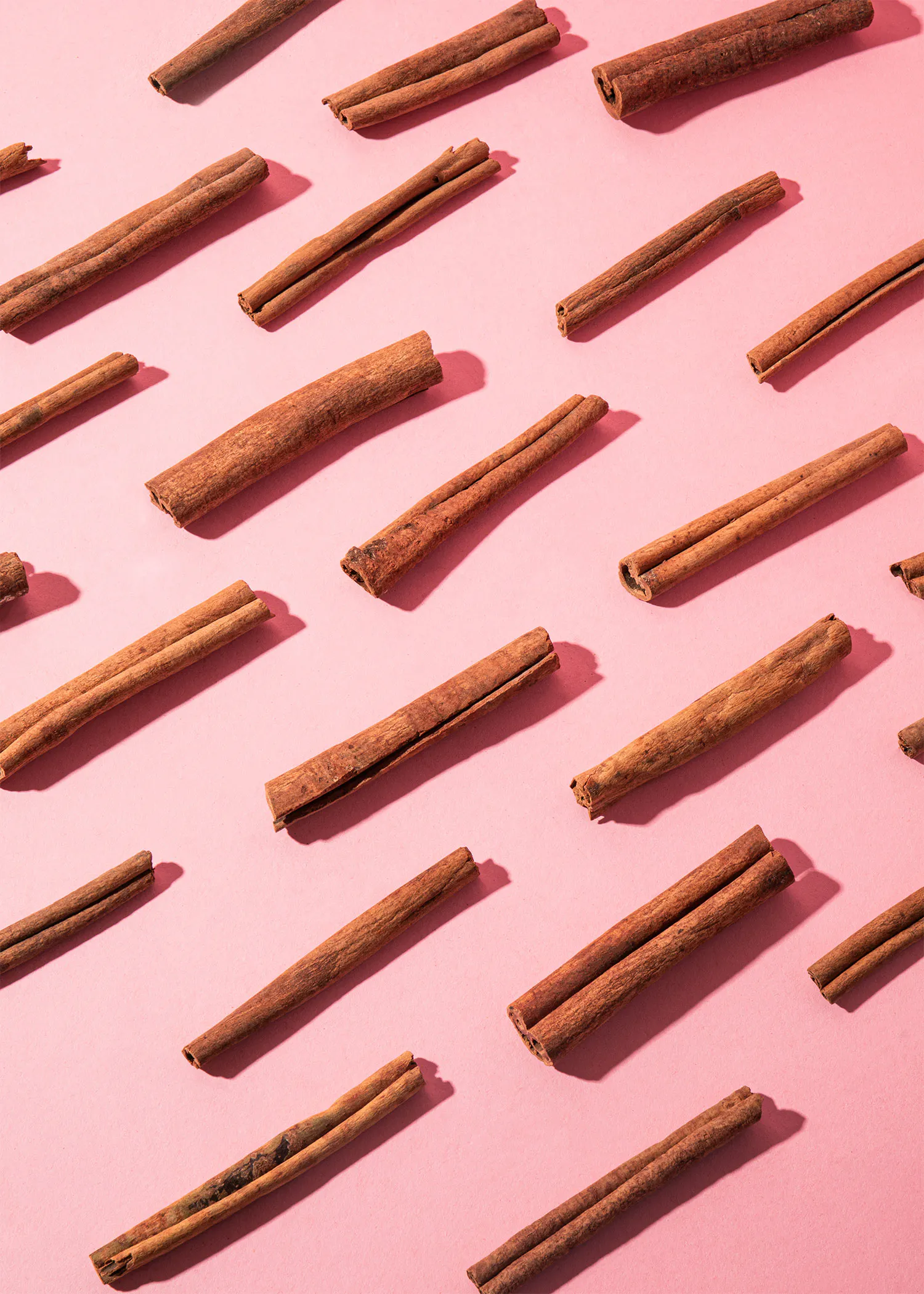 a pattern of cinnamon sticks on a pink background