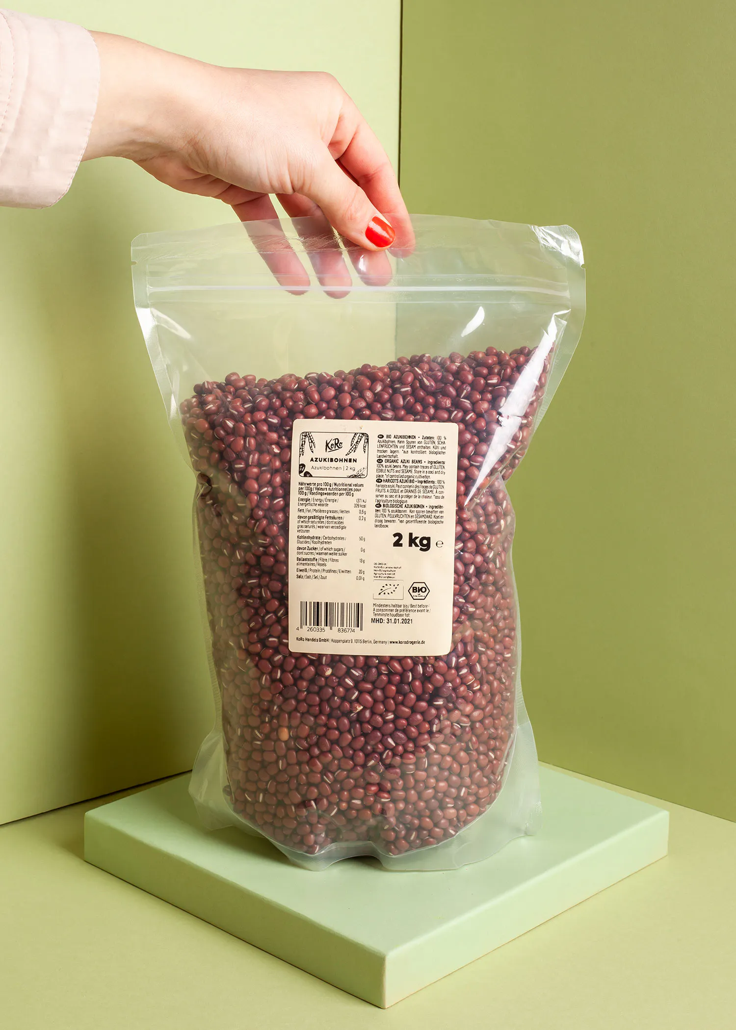 a person is holding a bag of red beans that says 2 kg