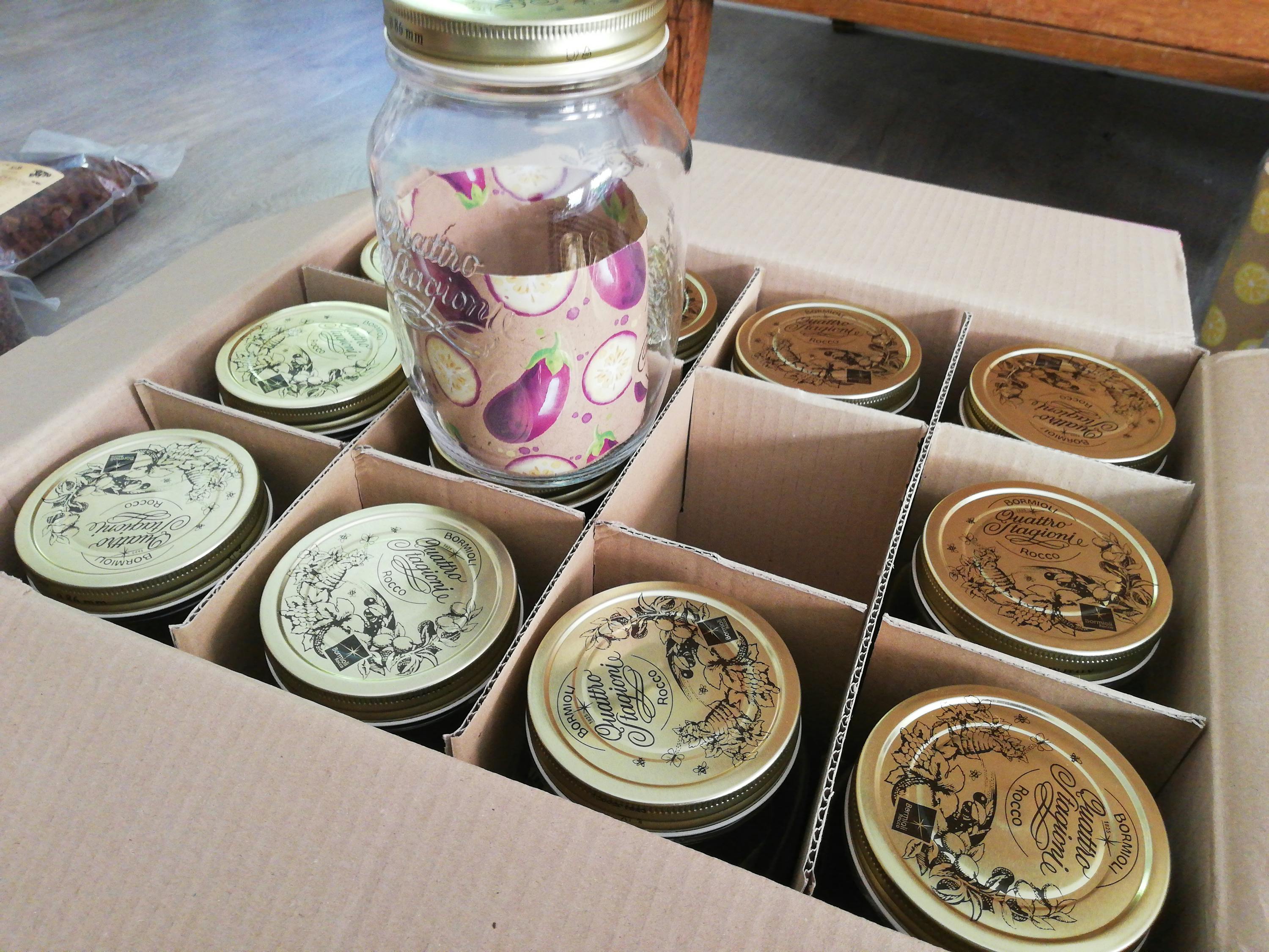 una scatola piena di barattoli di vetro e tappi