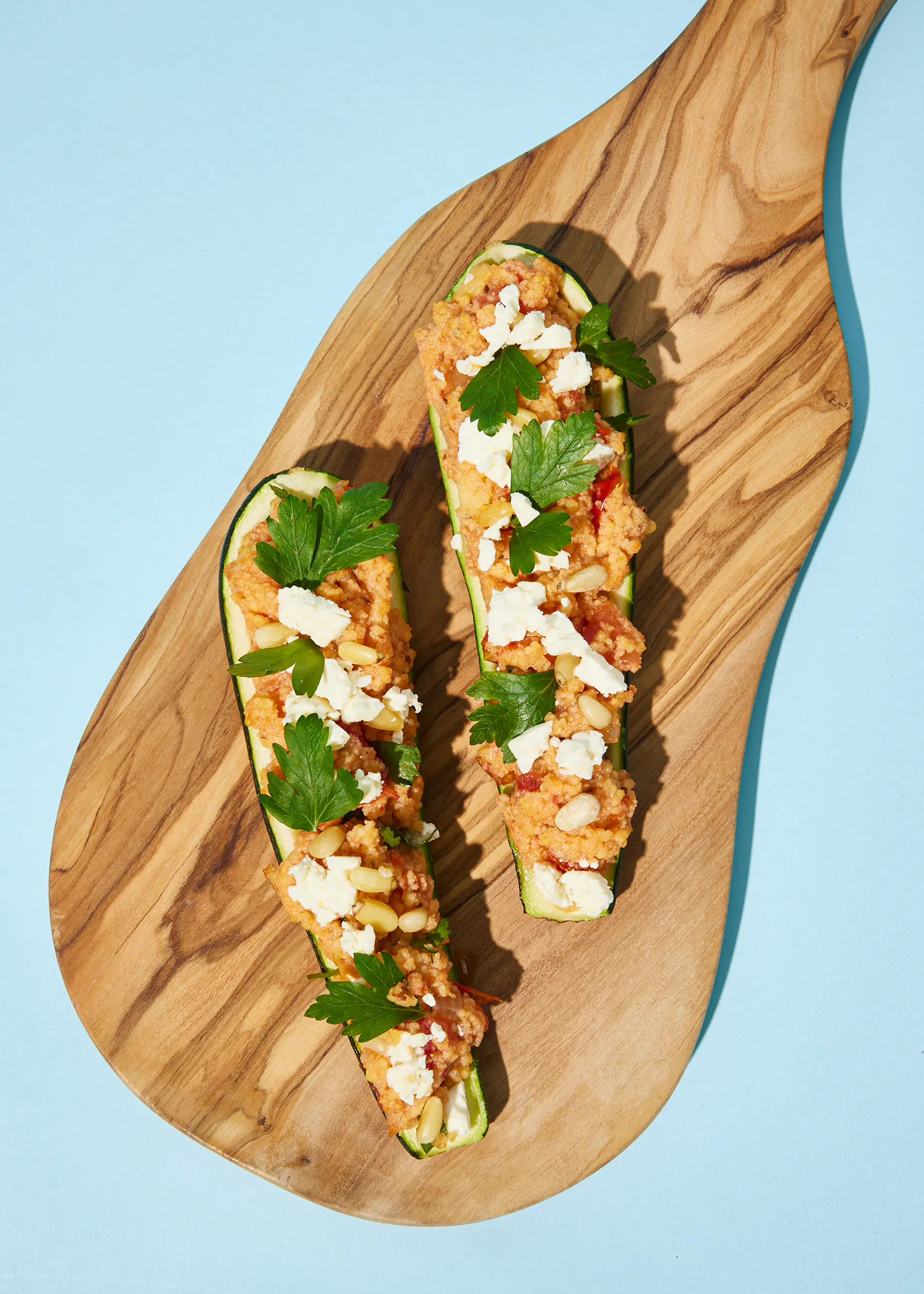 zwei gefüllte Zucchini auf einem Holzschneidebrett