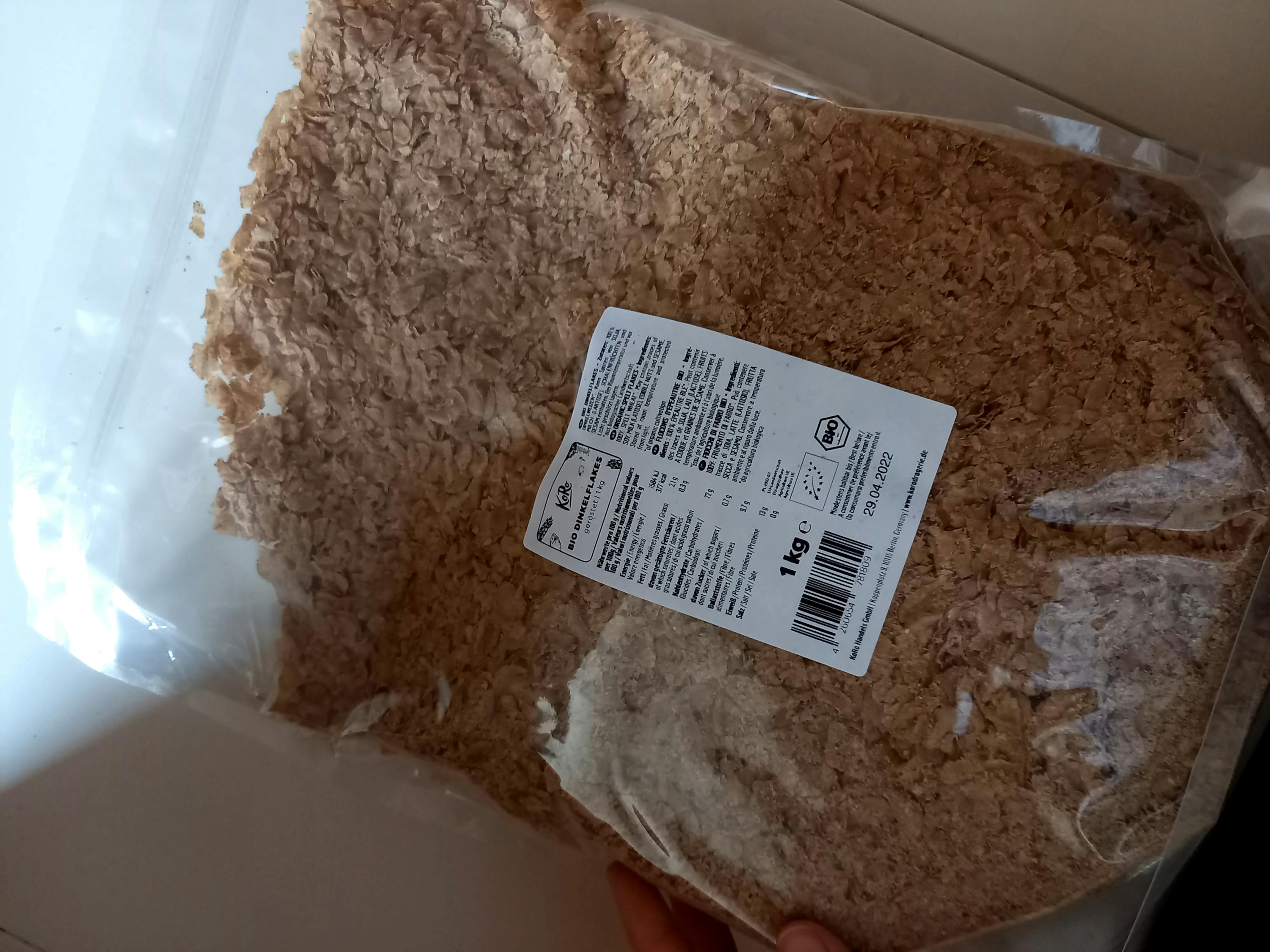 une personne tient un sac de farine avec une étiquette de 1 kg