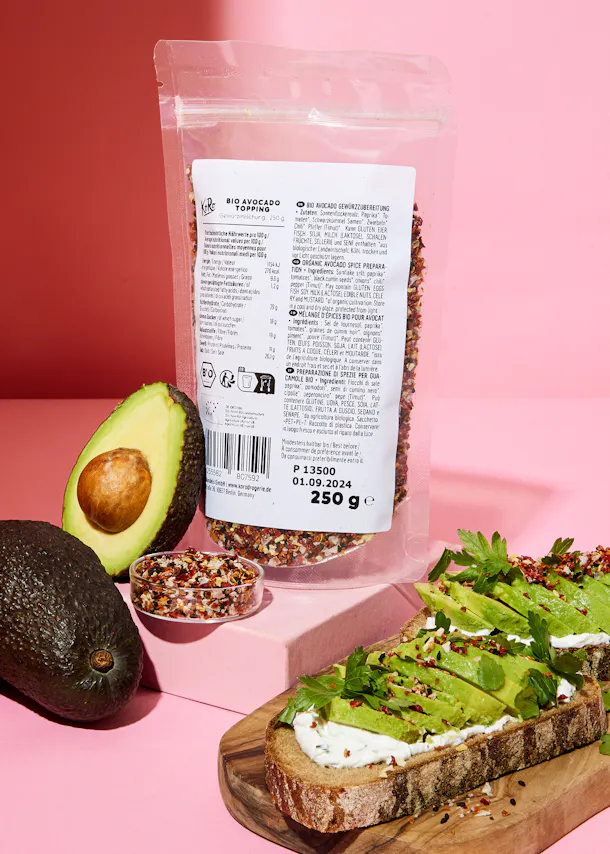 a bag of avocado seeds sits next to a sliced avocado