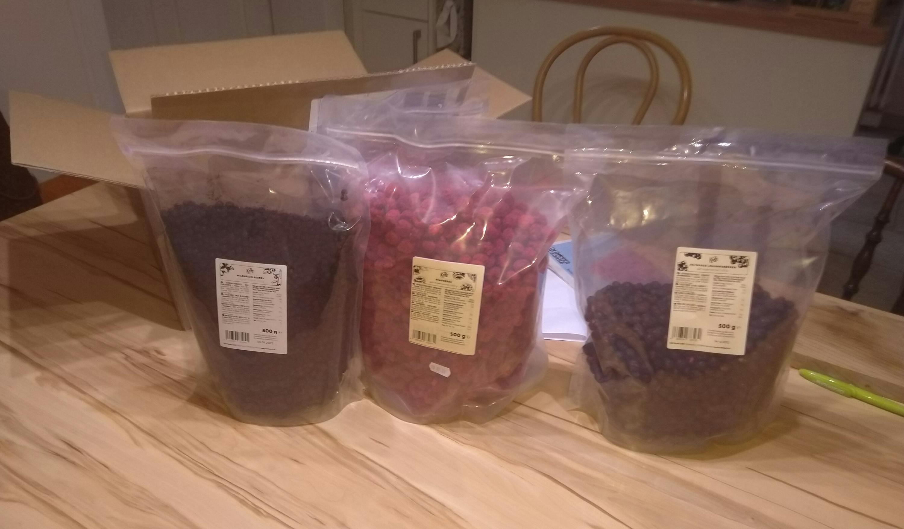 trois sacs de nourriture sont assis sur une table en bois