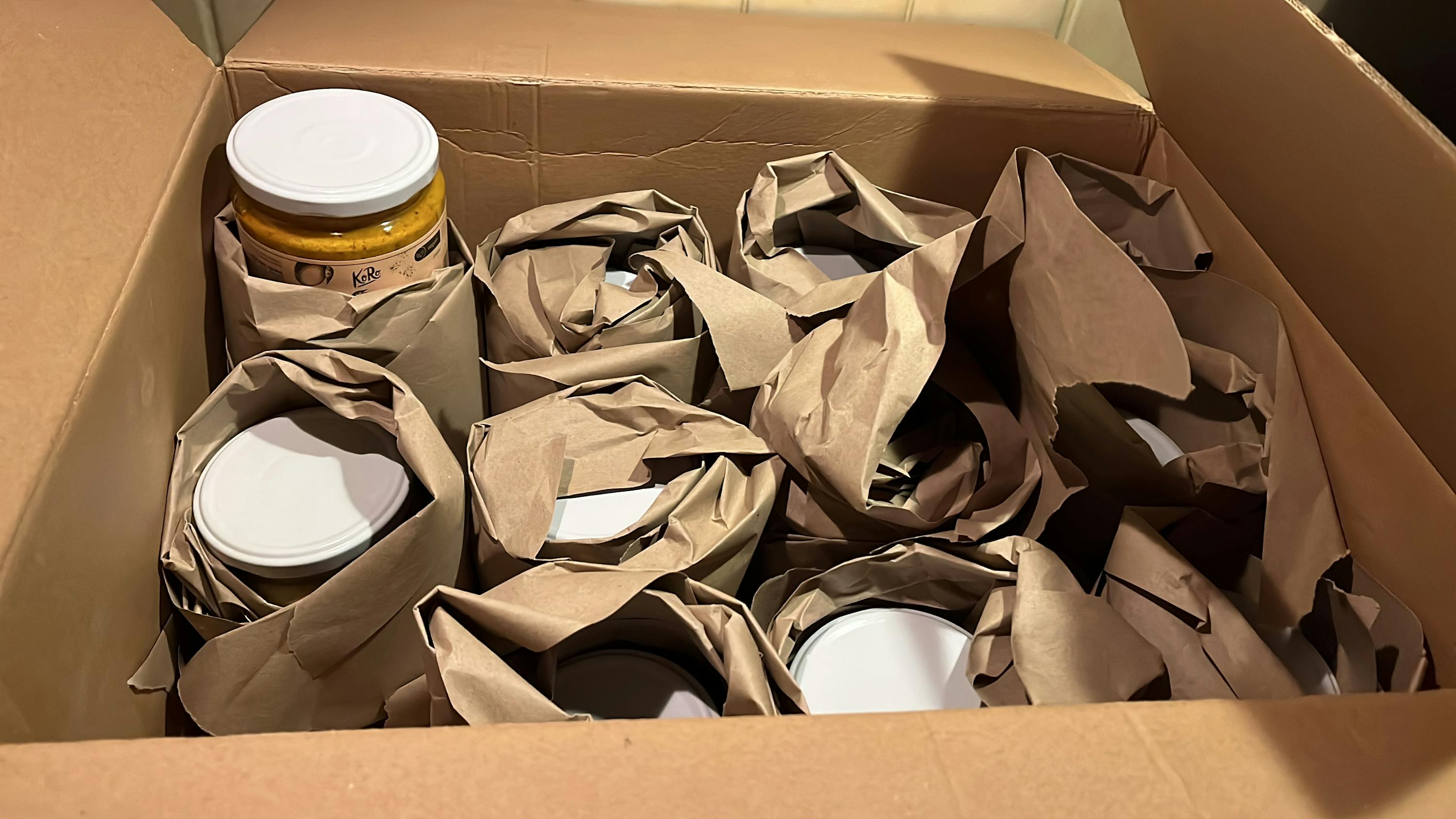 una scatola di cartone piena di barattoli e borse di carta