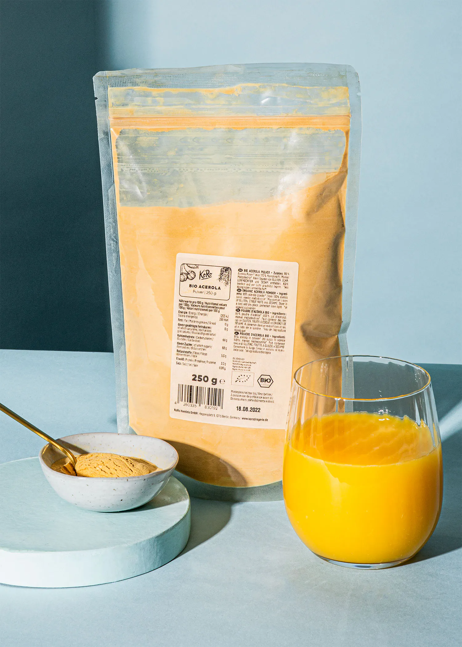 ein Glas Orangensaft steht neben einer Tüte Gewürzpulver