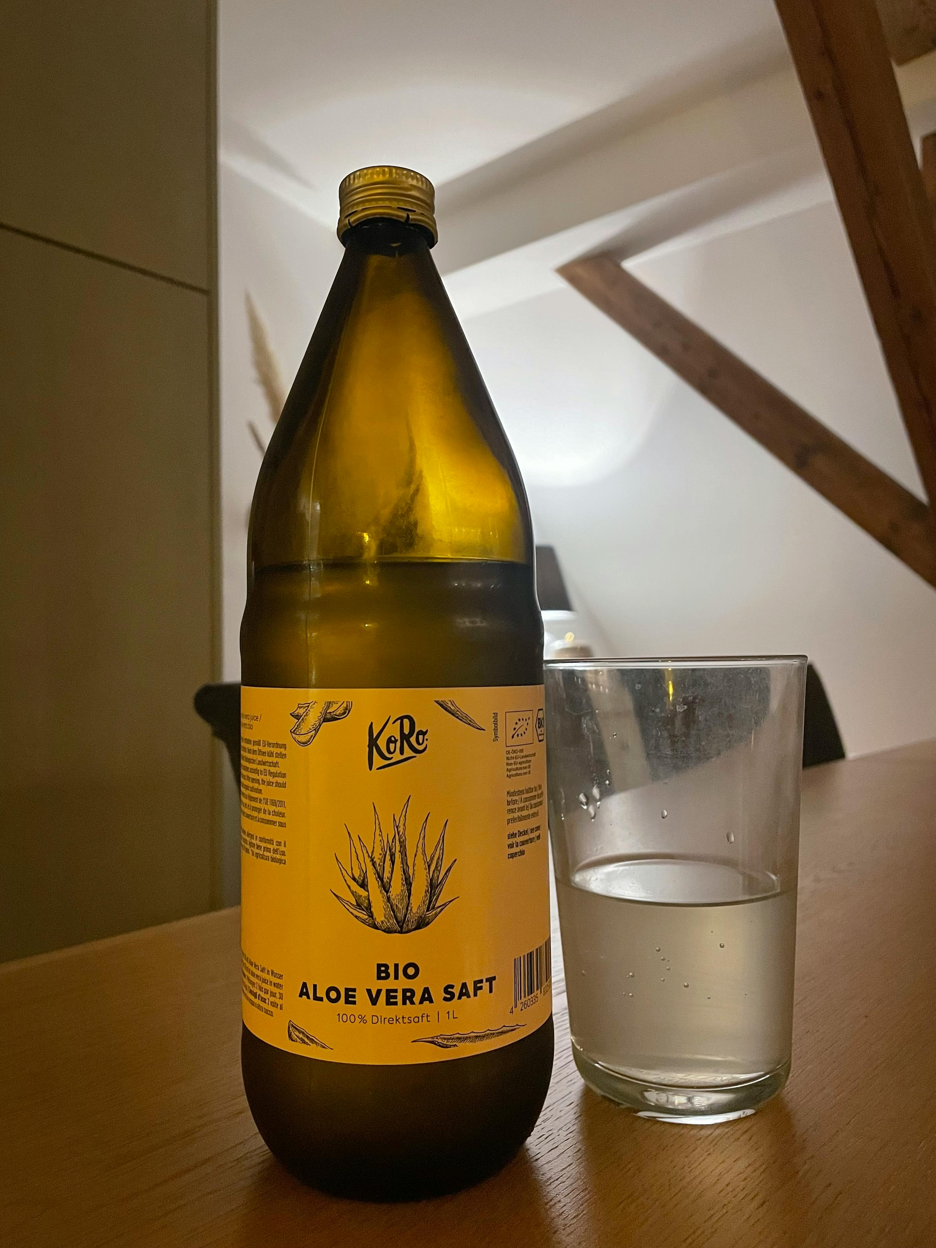 a bottle of bio aloe vera saft next to a glass