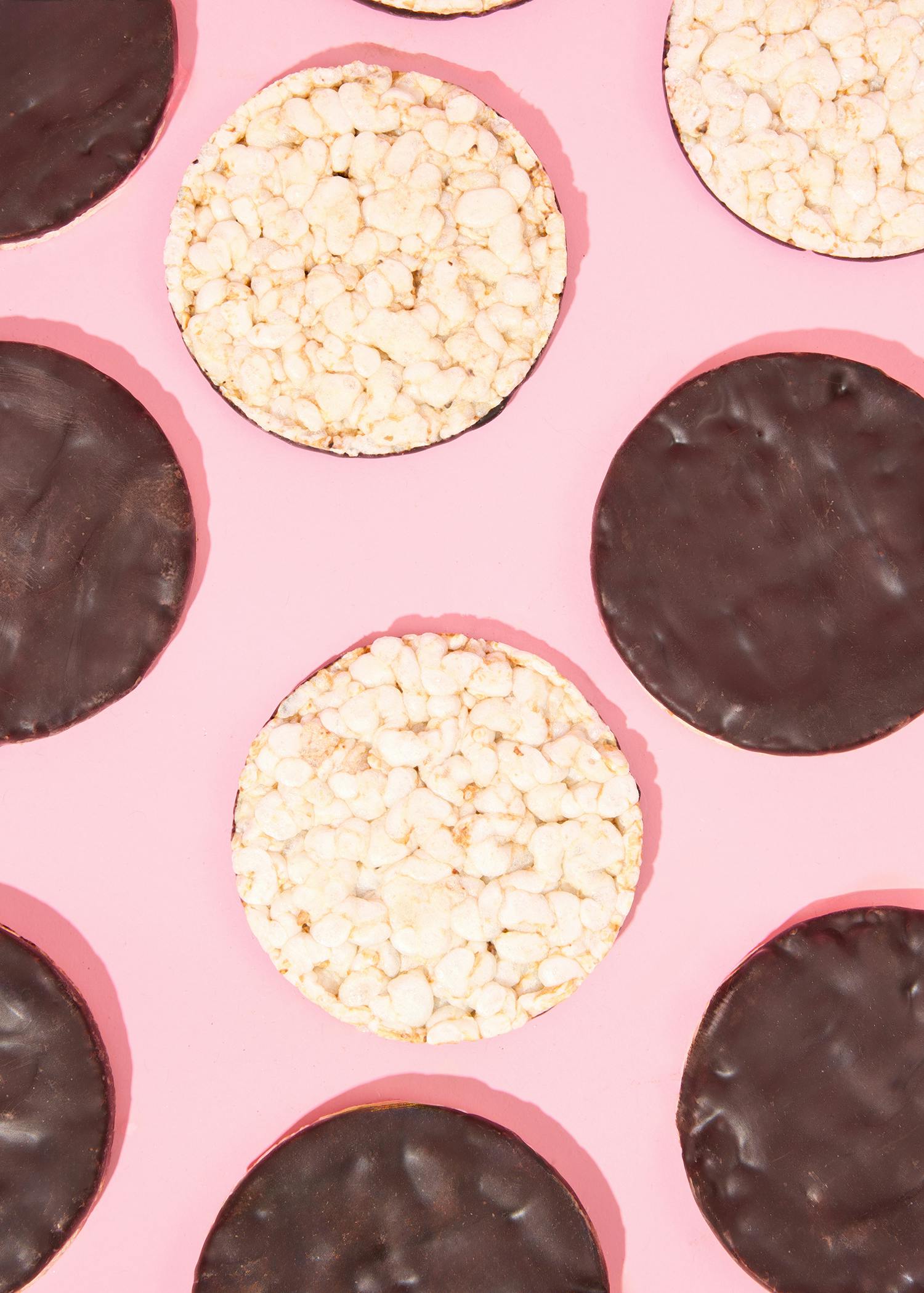 ein rosa Hintergrund mit einem nahtlosen Muster aus braunen und weißen Kekse