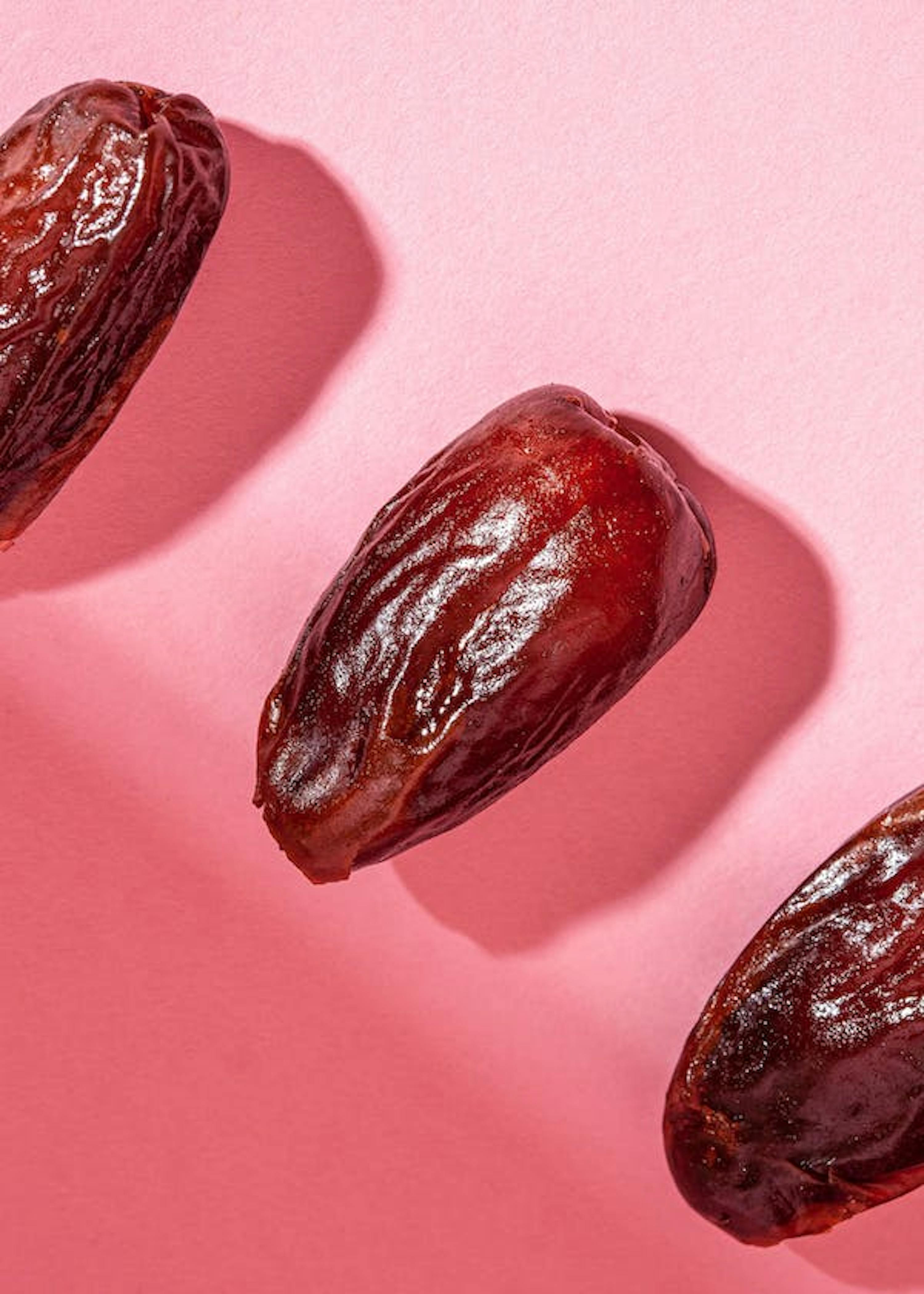 three dates are lined up on a pink background .