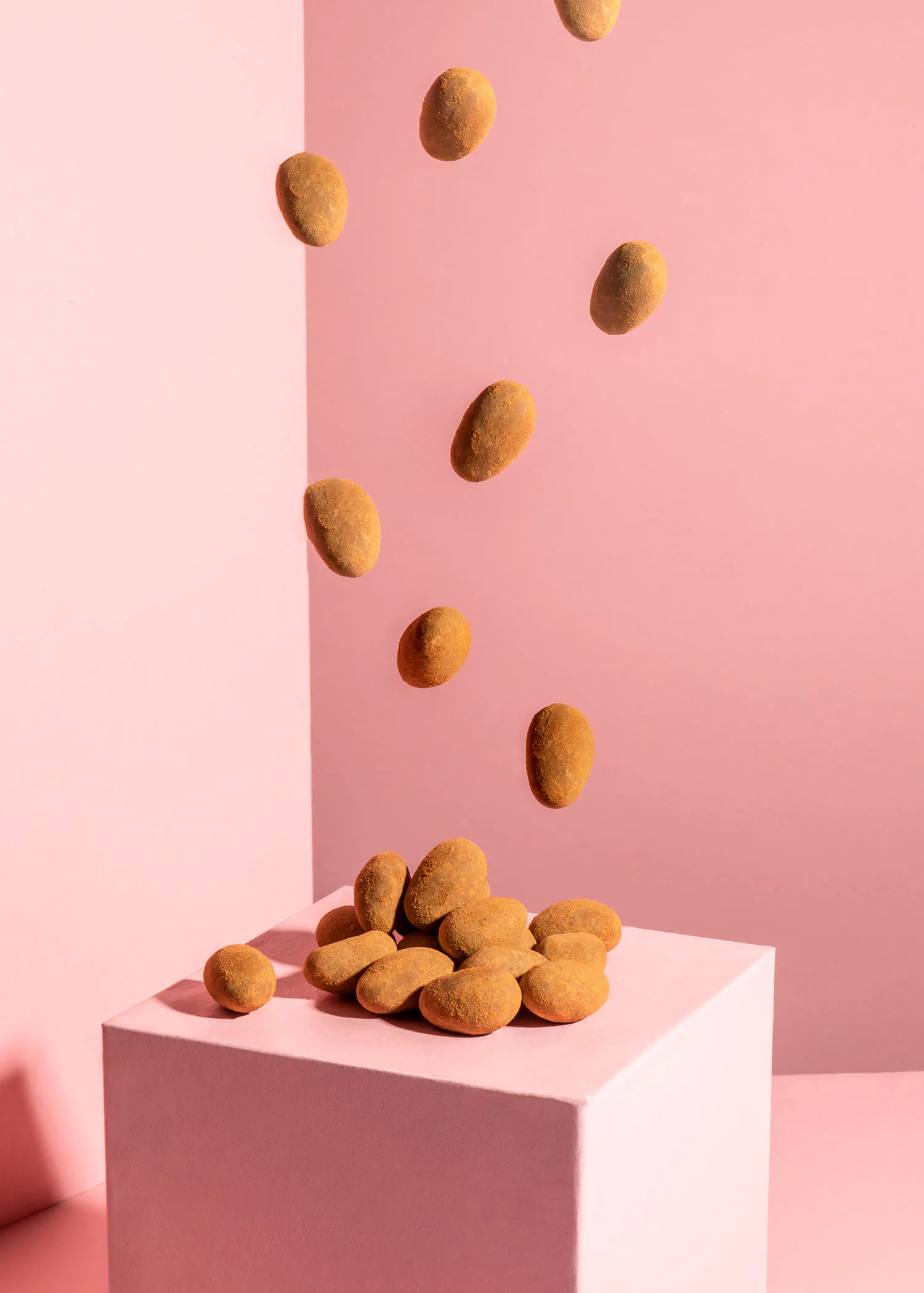 a pile of nuts are falling on a pink box