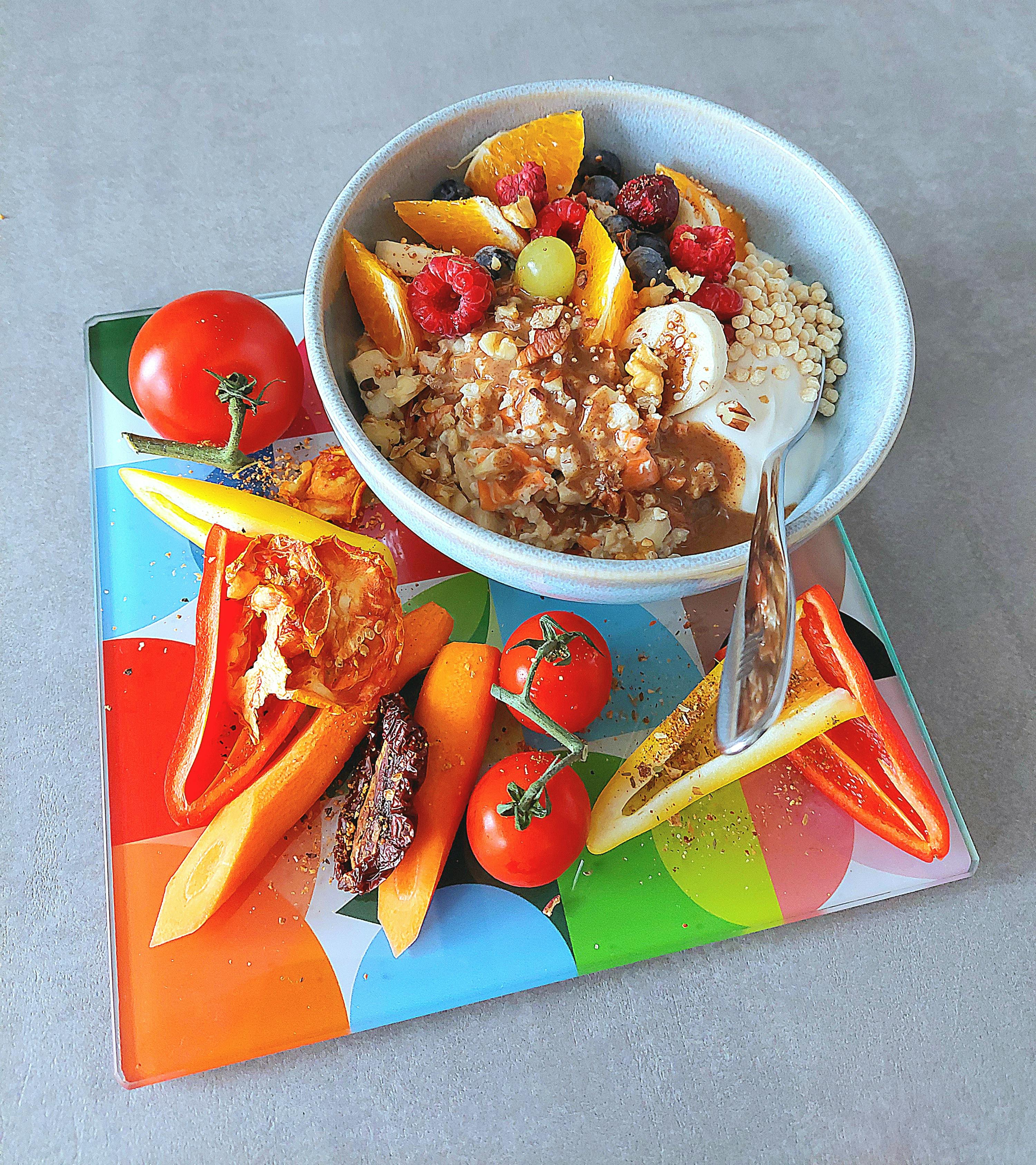 a bowl of oatmeal with fruit and vegetables on a plate