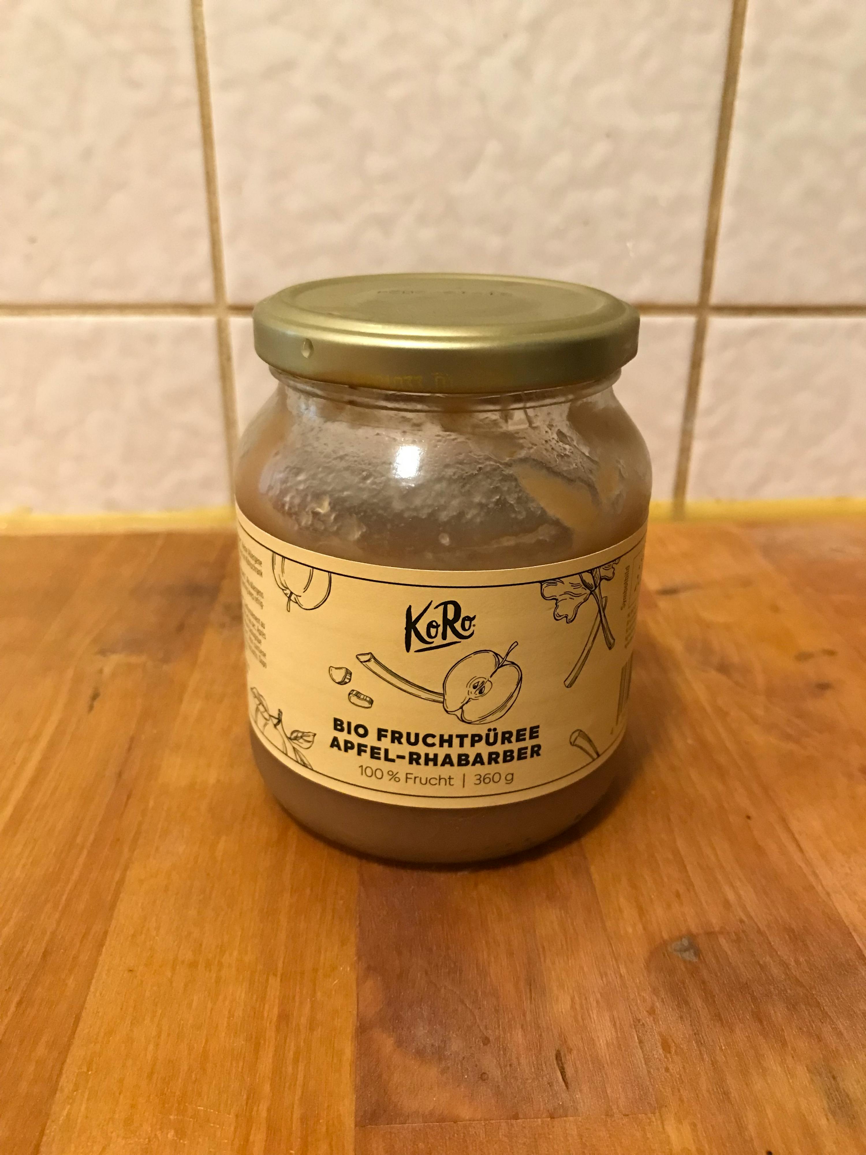 un barattolo di purea di frutta bio è seduto su un tavolo di legno