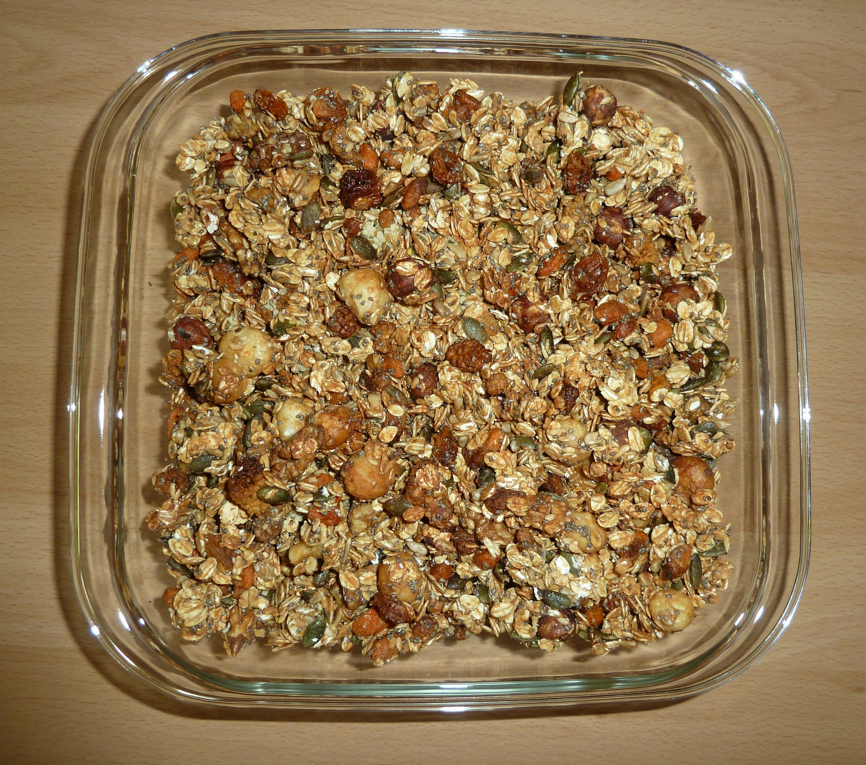 un contenitore di vetro pieno di granola e noci