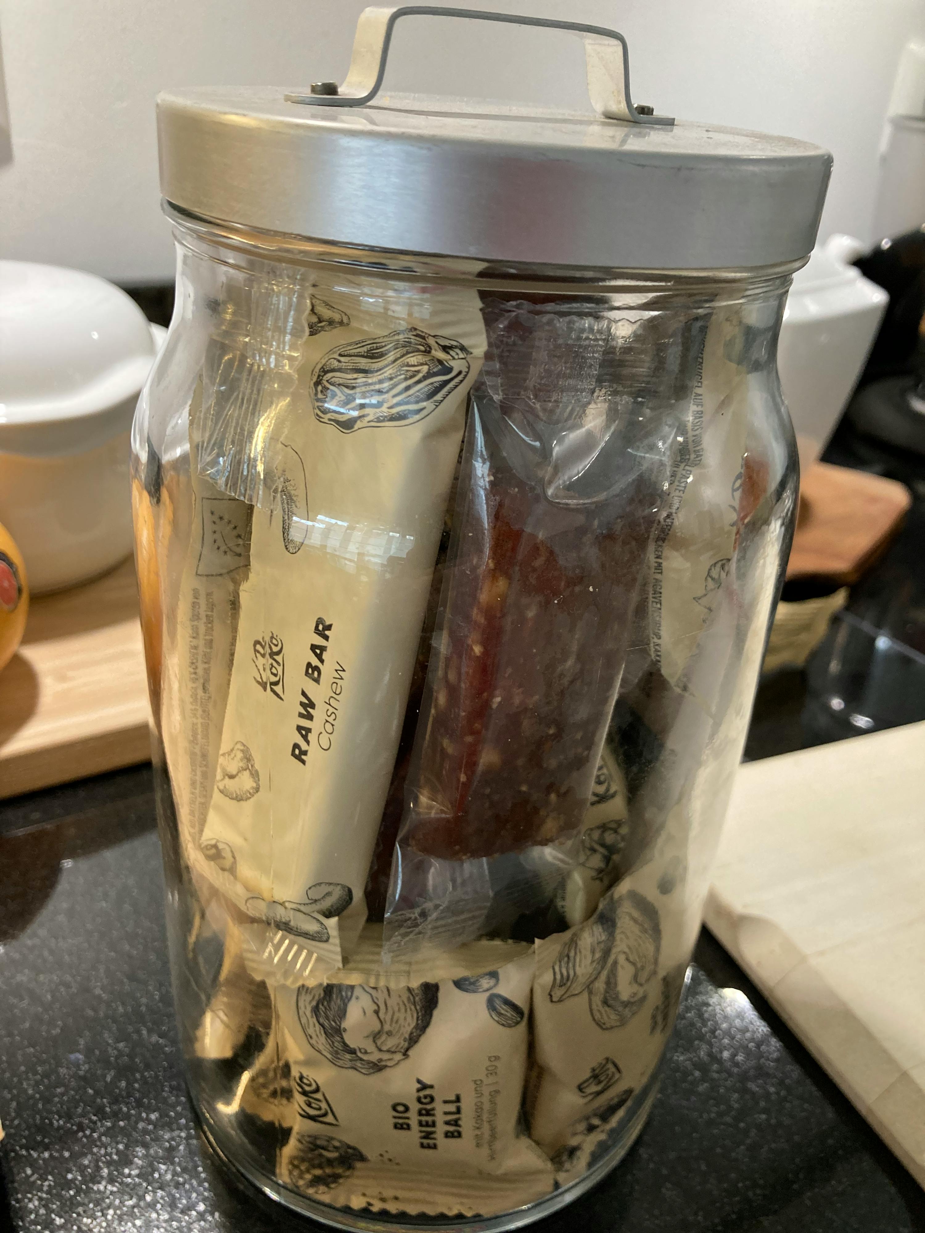 un bocal en verre rempli de barres de noix de cajou crues