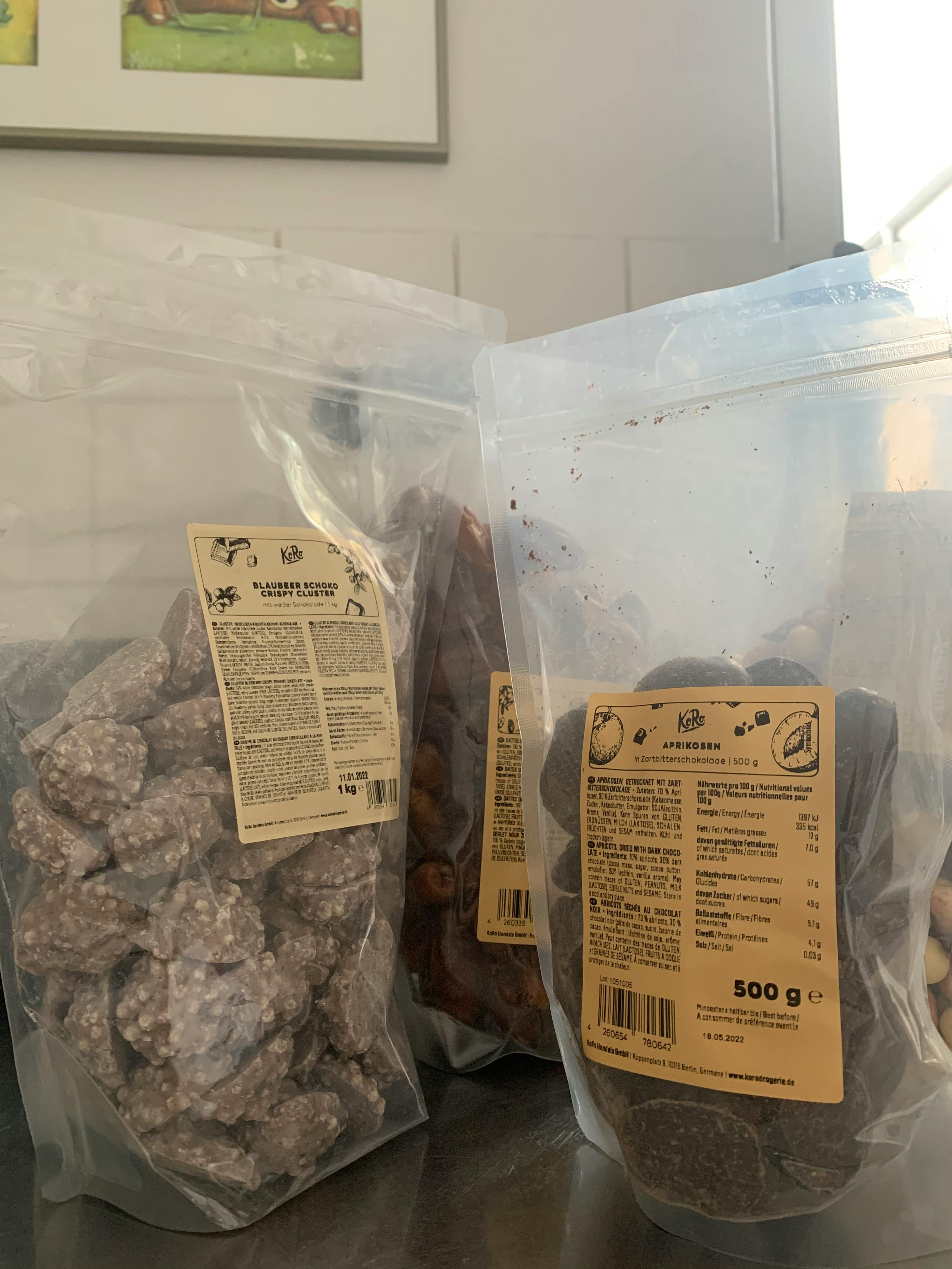 zwei Plastiktüten mit Schokoladenstücken und einer mit Erdnüssen