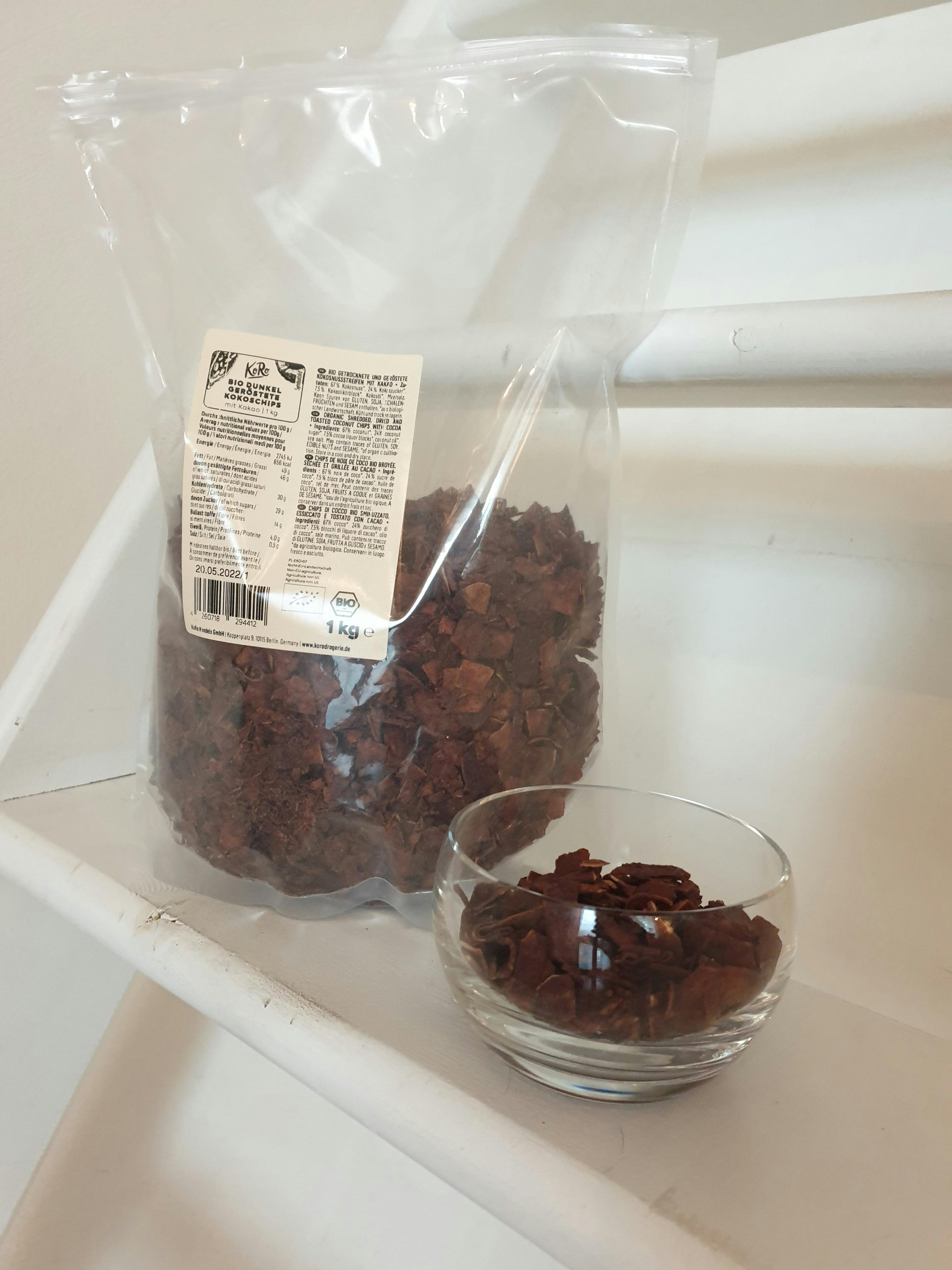 eine Tüte Schokoladenflocken steht neben einer Glasschale