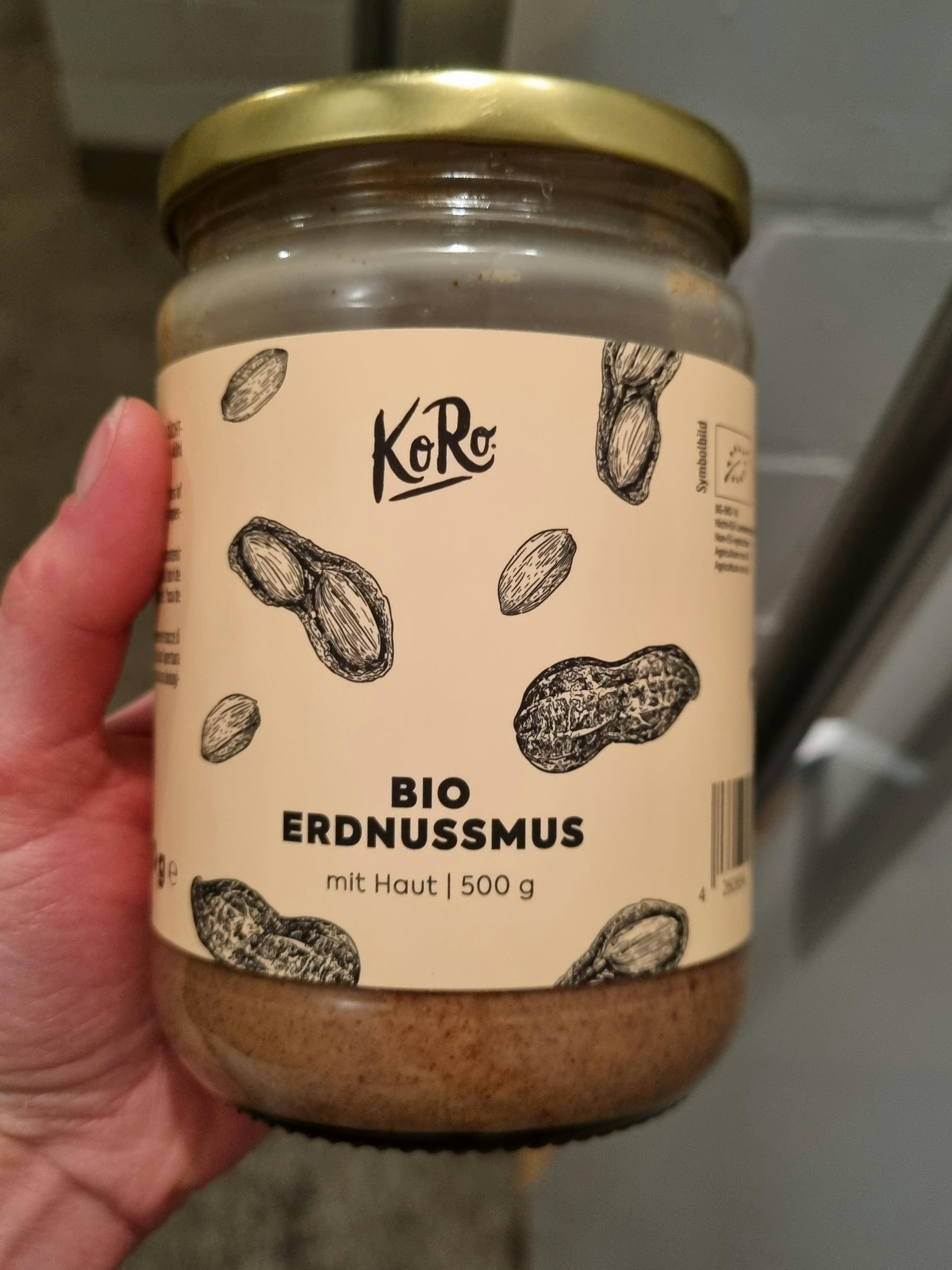 a jar of bio erdnussmus is being held in someone 's hand
