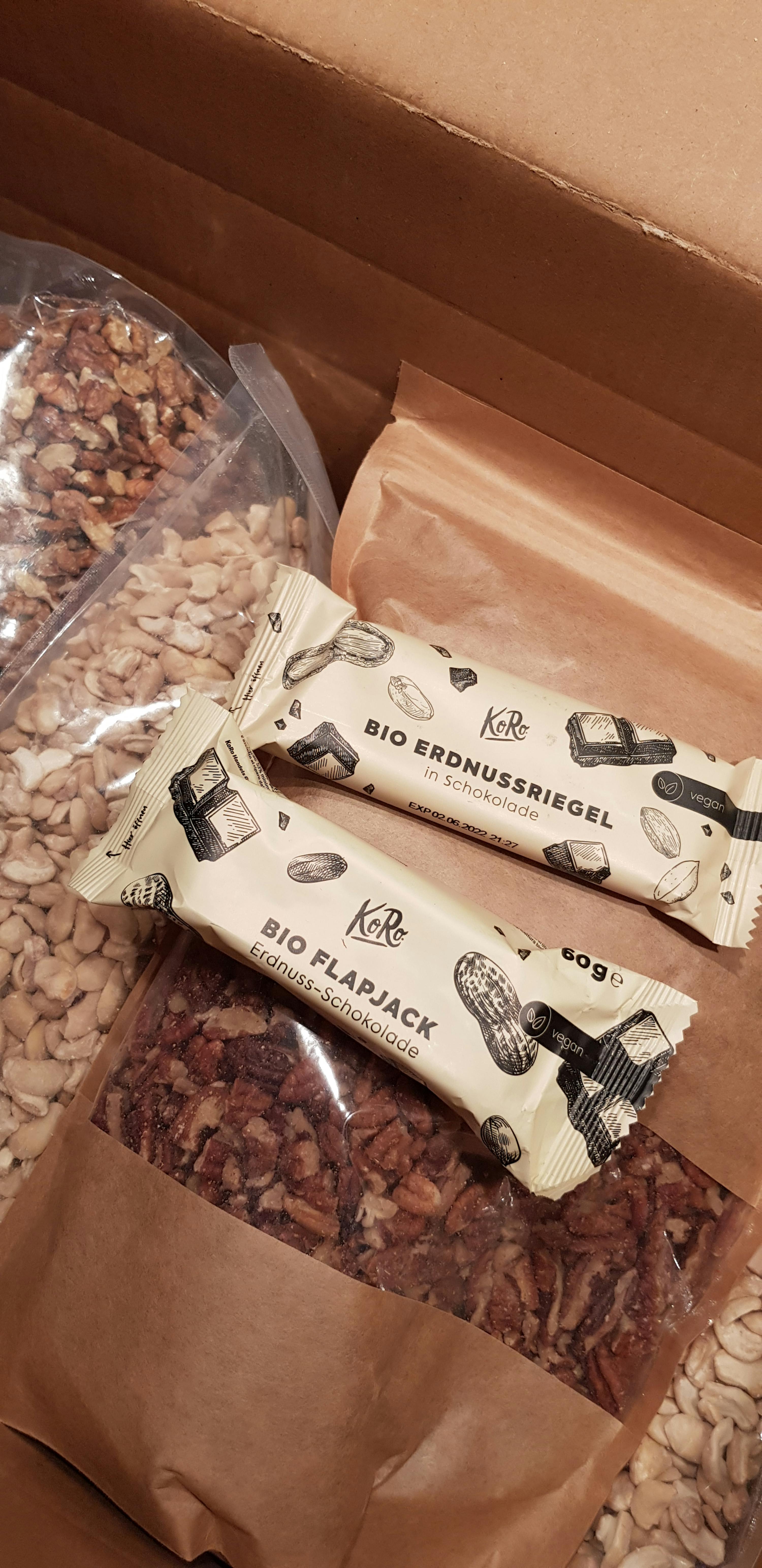 deux barres bio erdnussriegel sont assises à côté d' un sac de cacahuètes