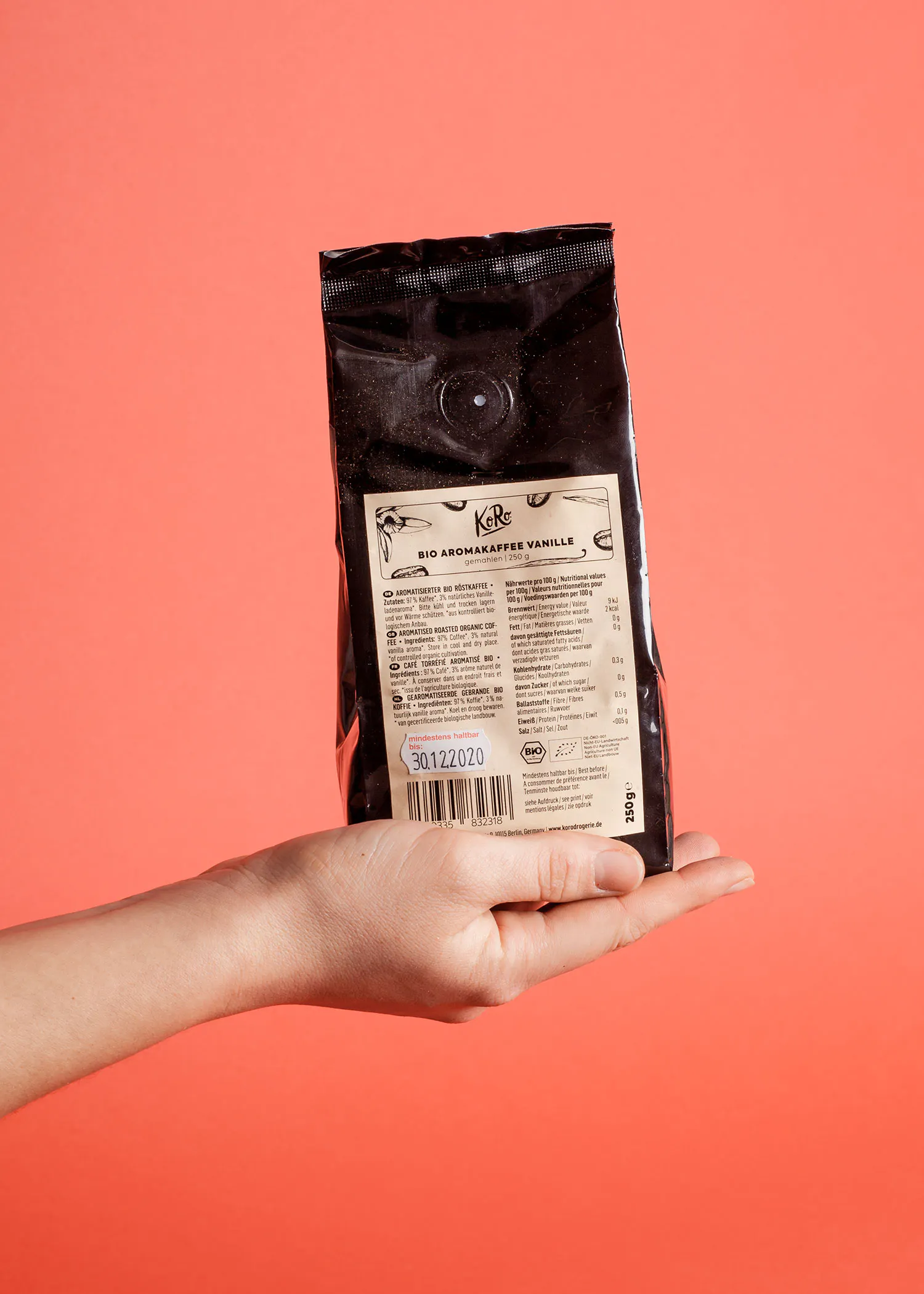 une main tient un sac de vanille bio