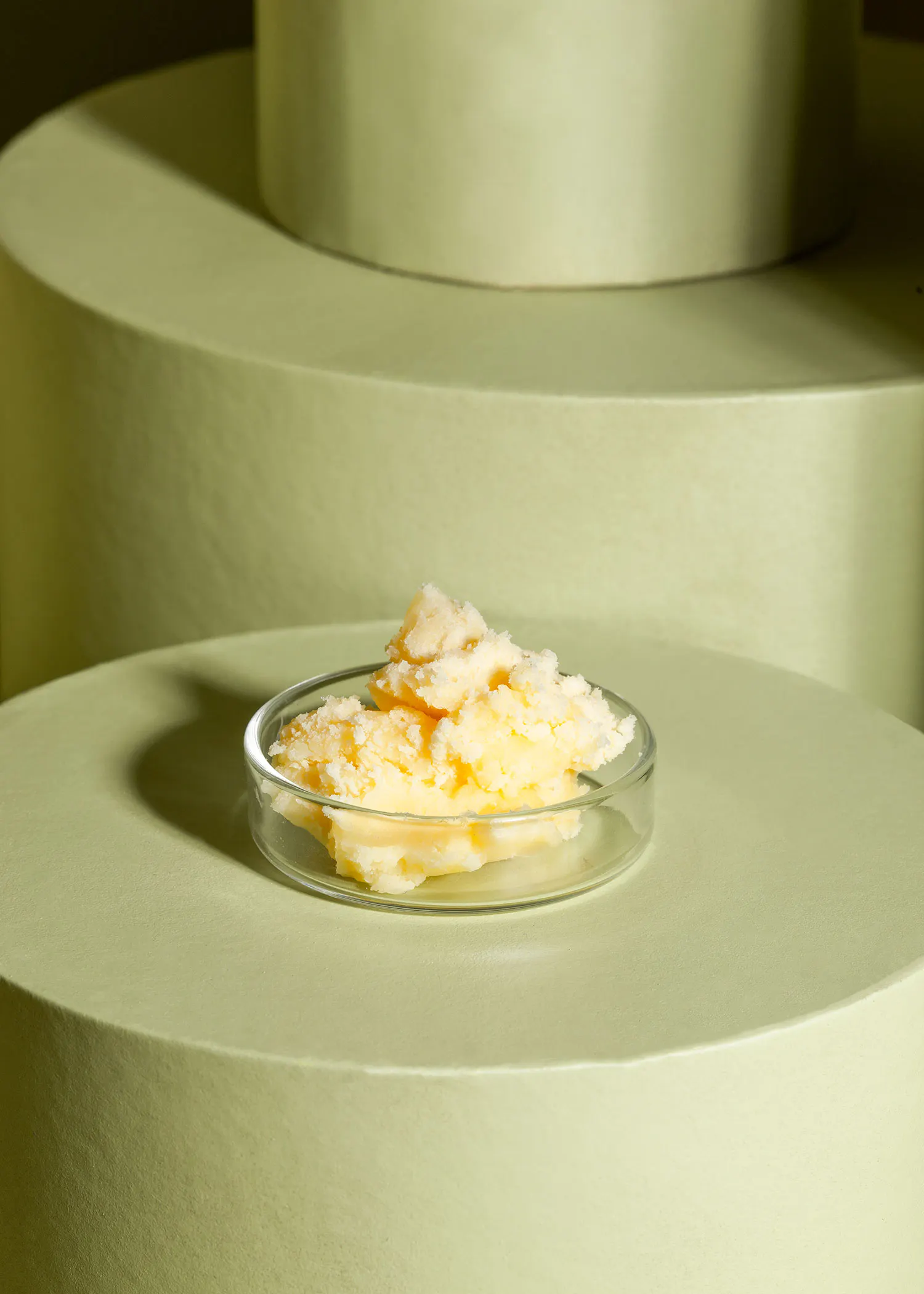 un bol en verre rempli d' un liquide jaune est posé sur une surface verte