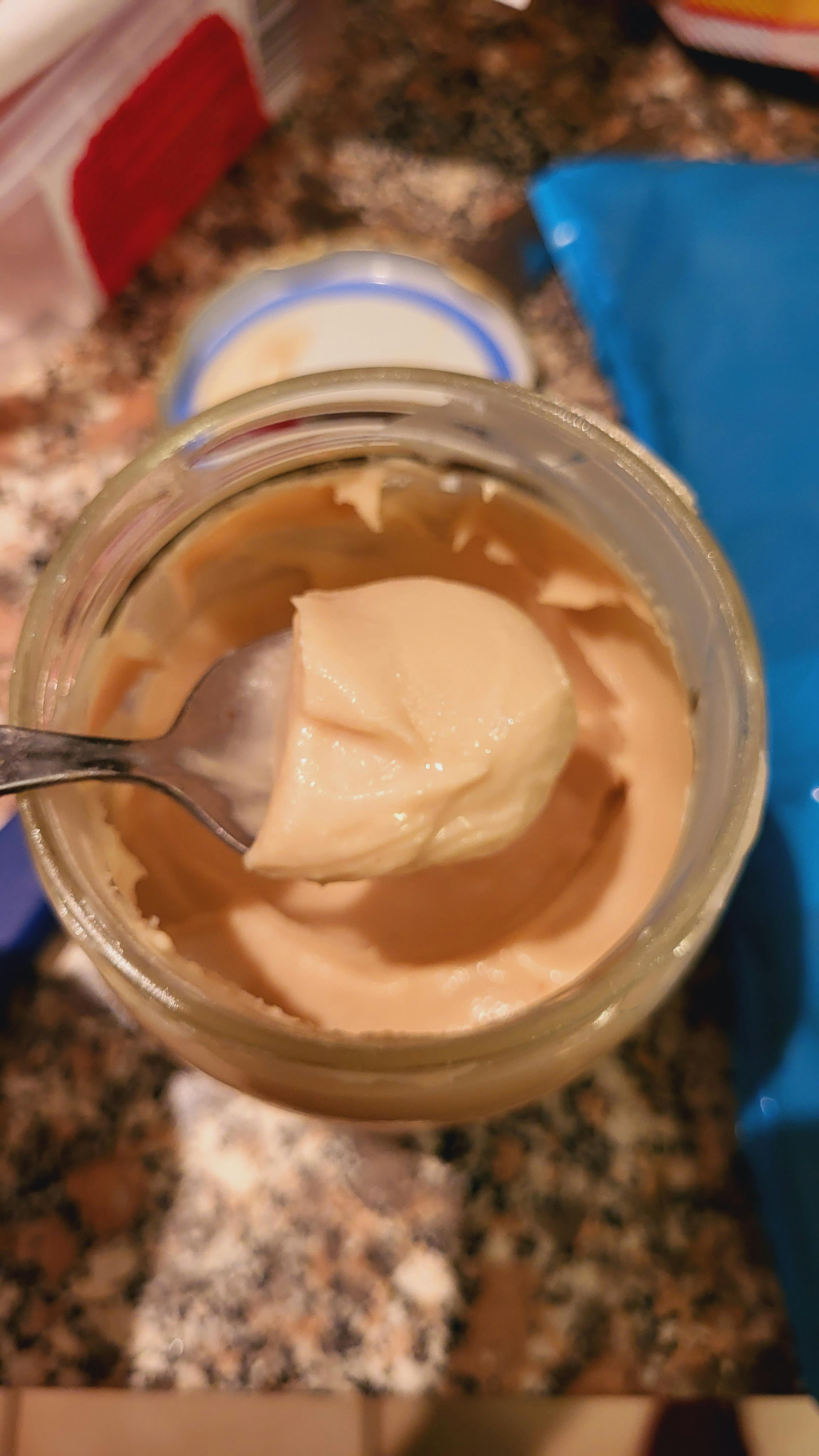 a jar of mayonnaise with a spoon sticking out of it