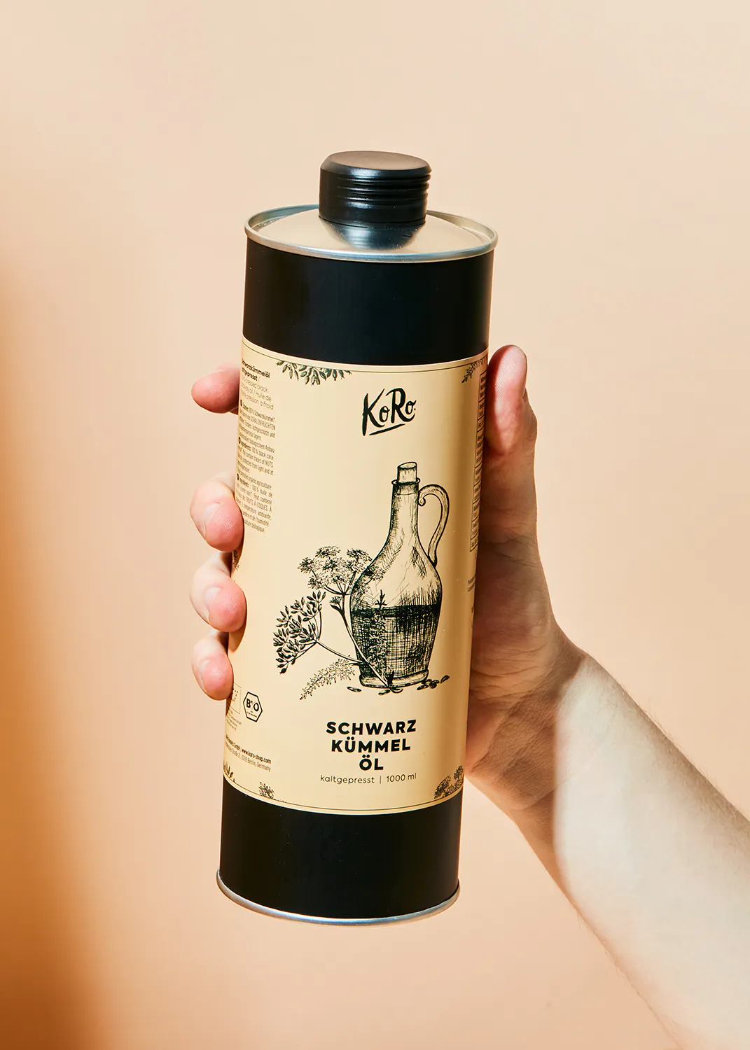 eine Person hält eine Dose schwarzkümmelöl in ihrer Hand