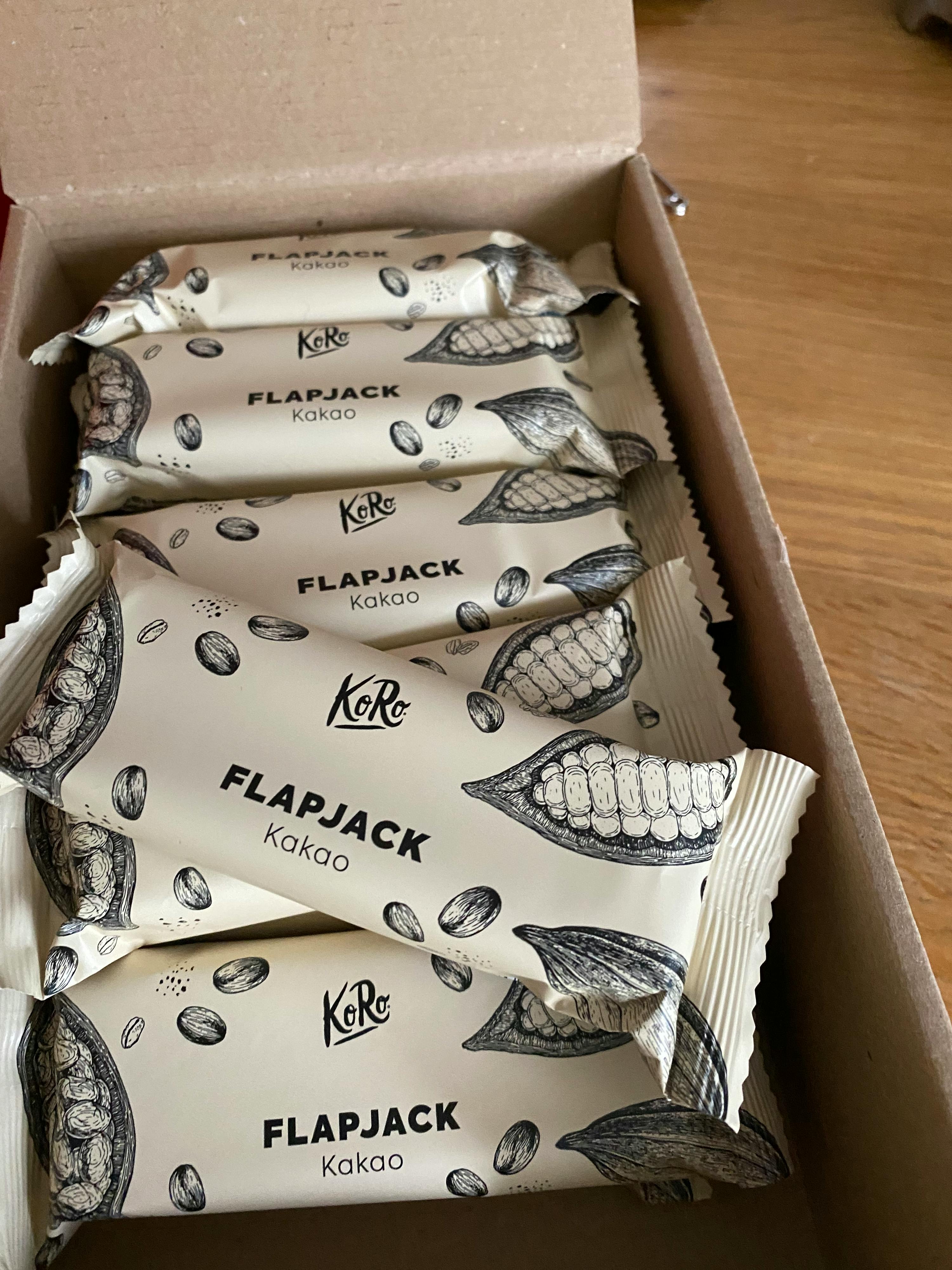 a box of flapjack kakao bars sits on a wooden table