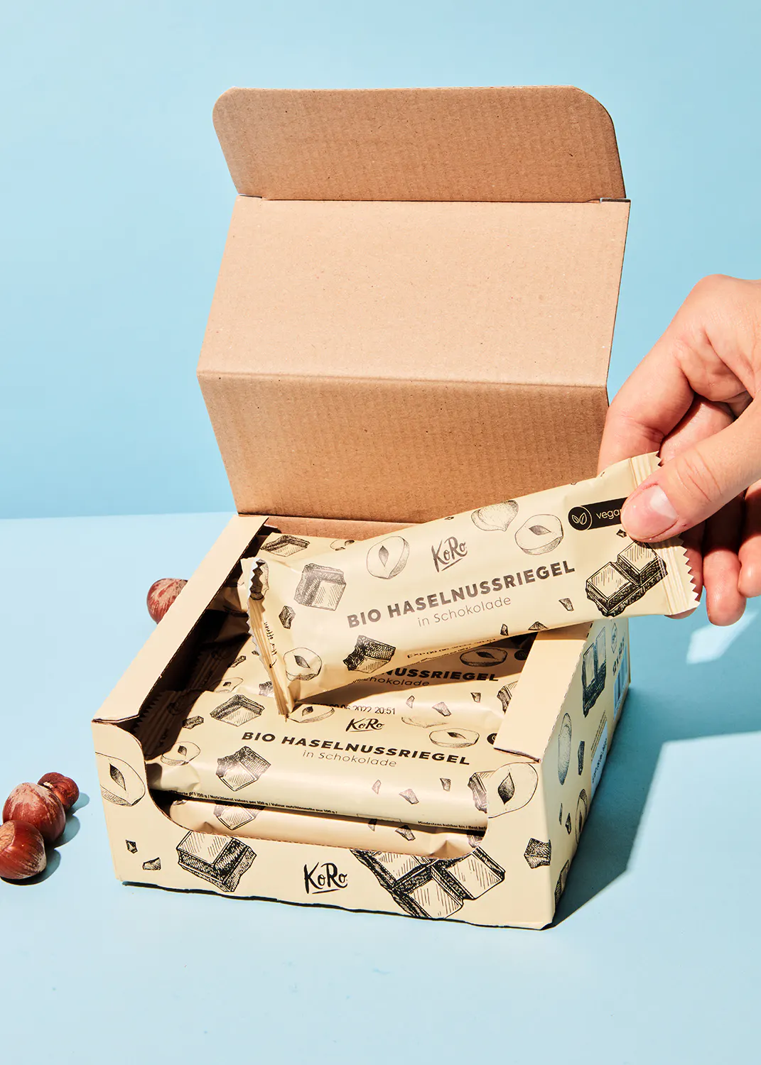 eine hand nimmt einen haselnussriegel aus einer box