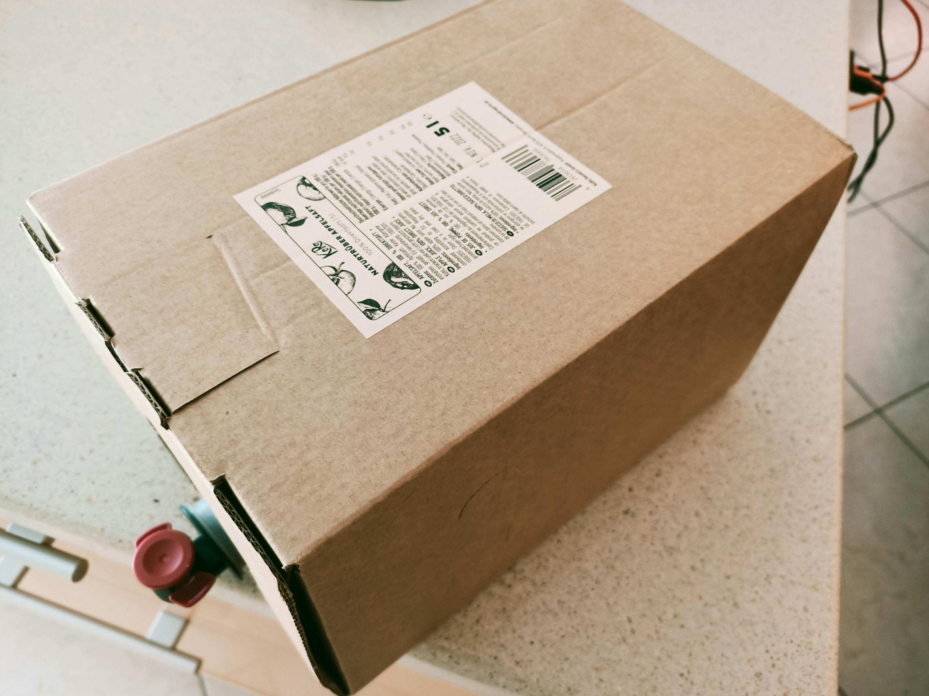 une boîte en carton marron avec une étiquette blanche sur le dessus
