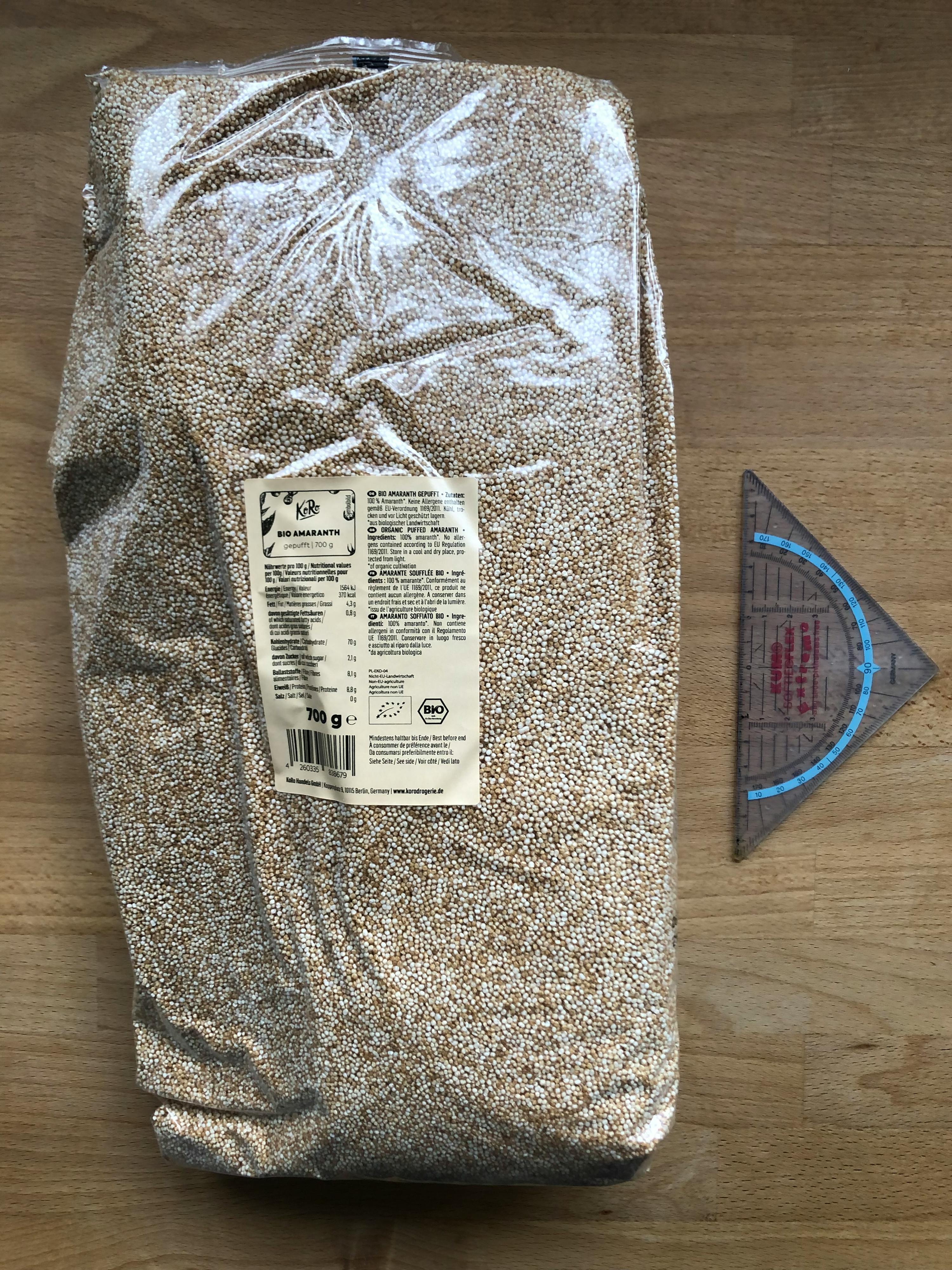 un sac de graines de quinoa est posé sur une table en bois