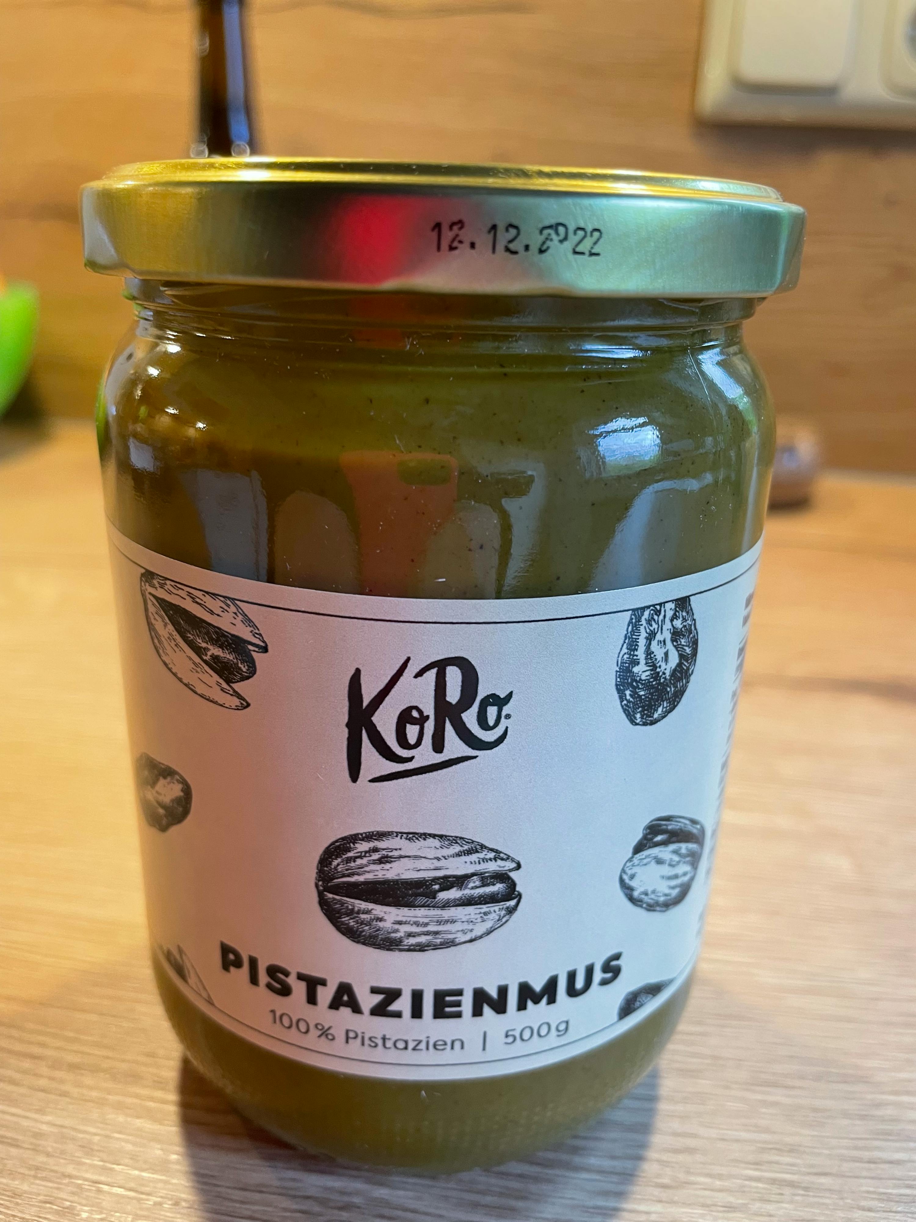 a jar of pistazienmus is sitting on a wooden table