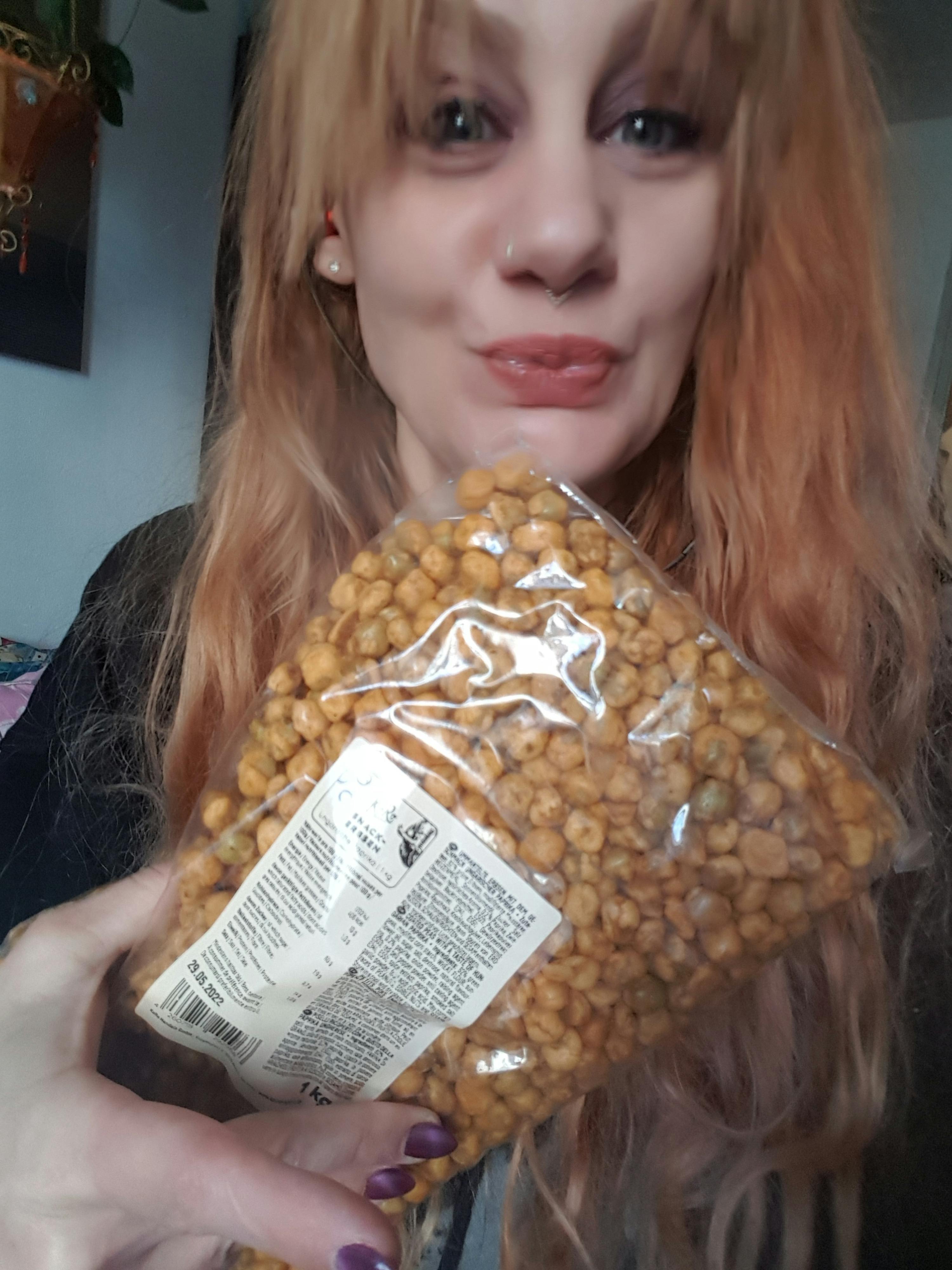 una donna tiene in mano un sacchetto di ceci con un etichetta bianca