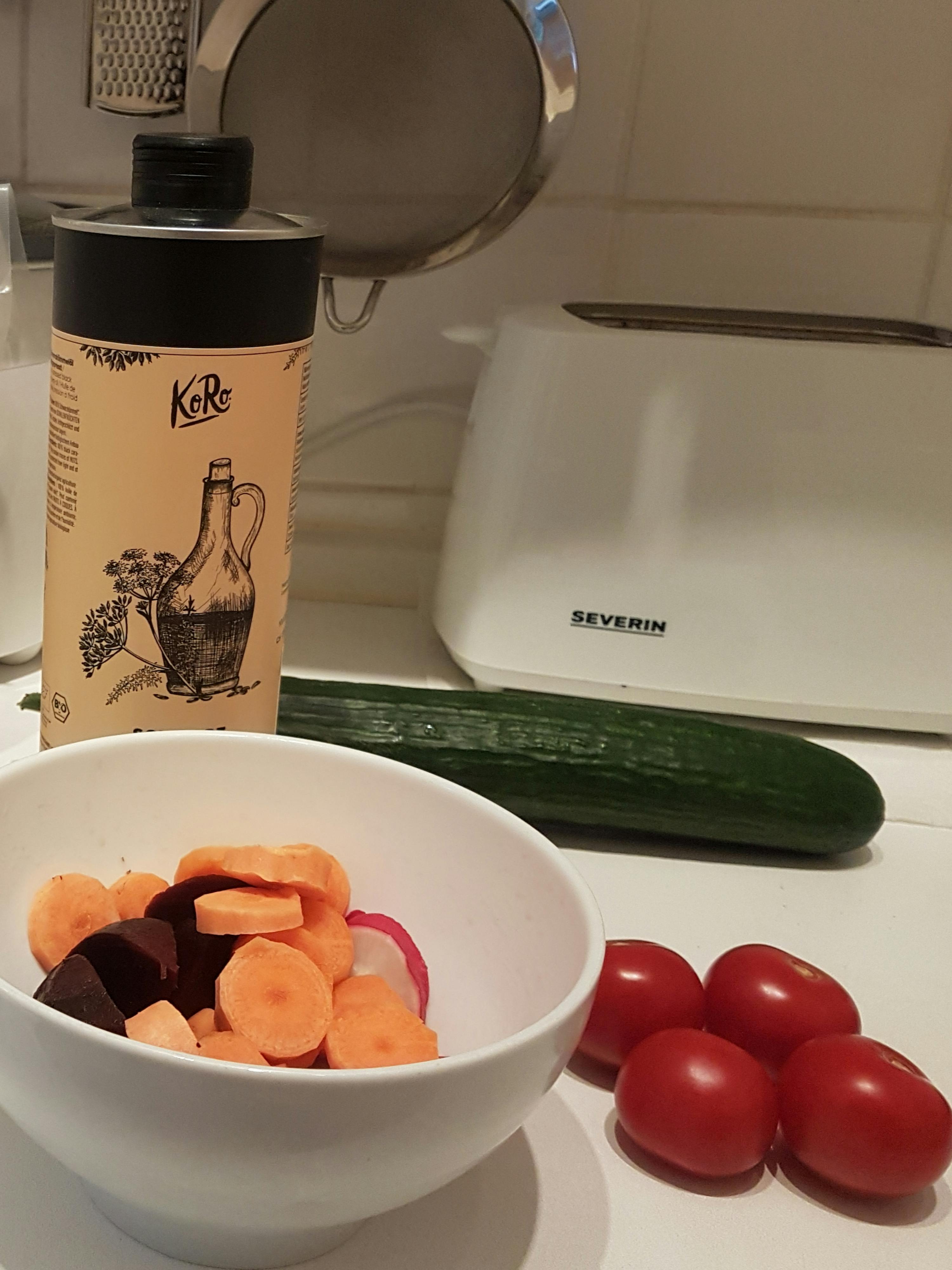 eine weiße schüssel mit geschnittenem gemüse steht neben einem toaster mit der schrift severin