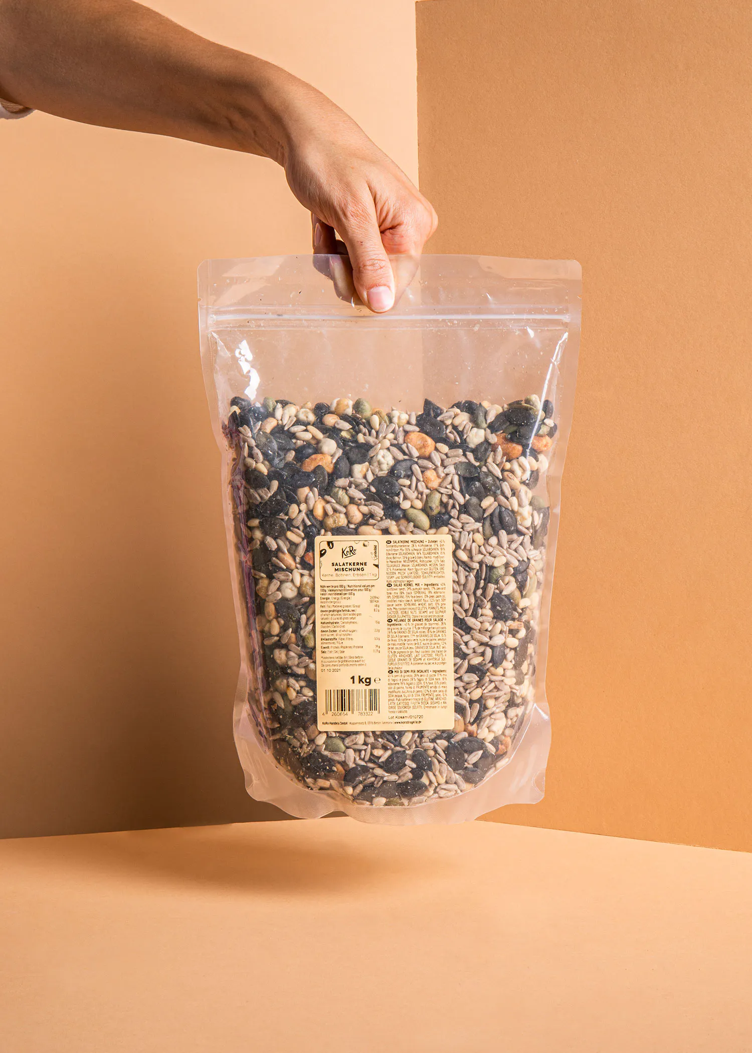 une personne tient un sac en plastique rempli de graines et de noix