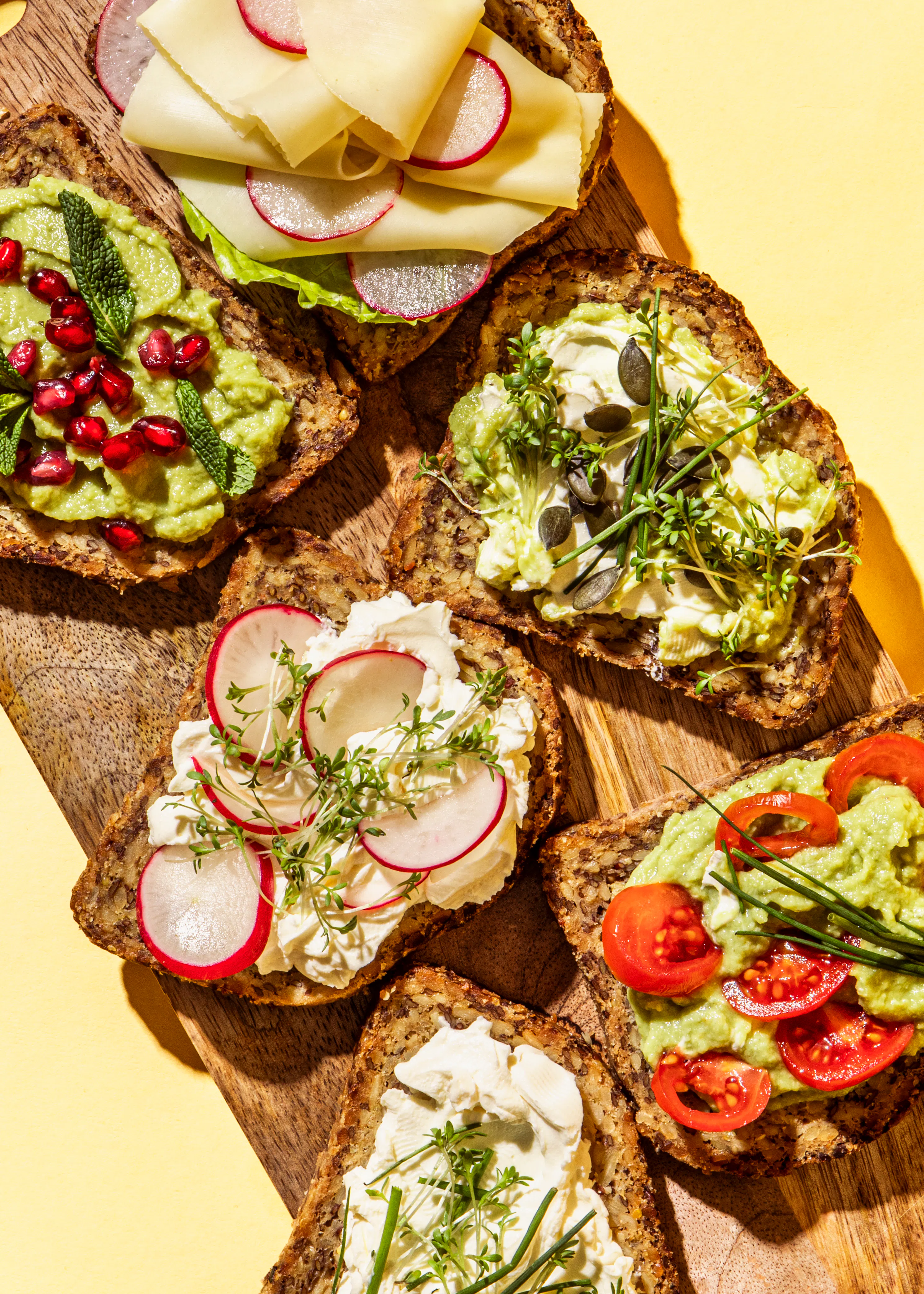 ein Schneidebrett mit verschiedenen Arten von Brot und Gemüse