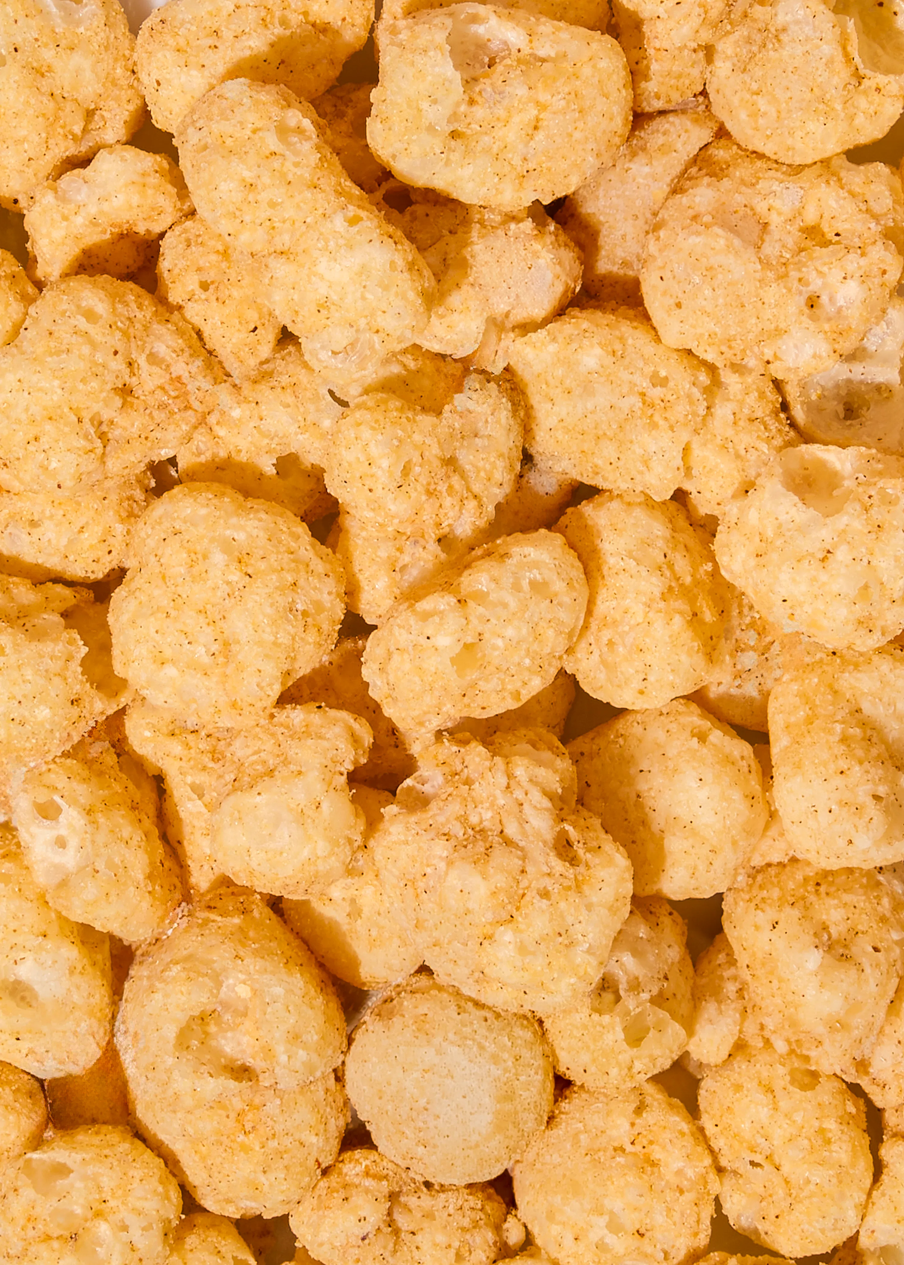 primo piano di snack croccanti al mais di colore giallo dorato.