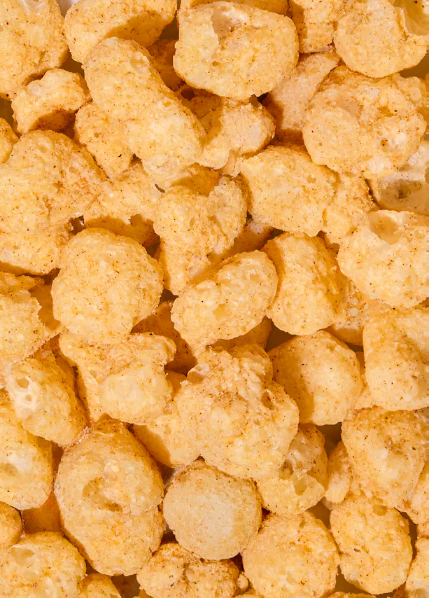 primo piano di snack croccanti al mais di colore giallo dorato.