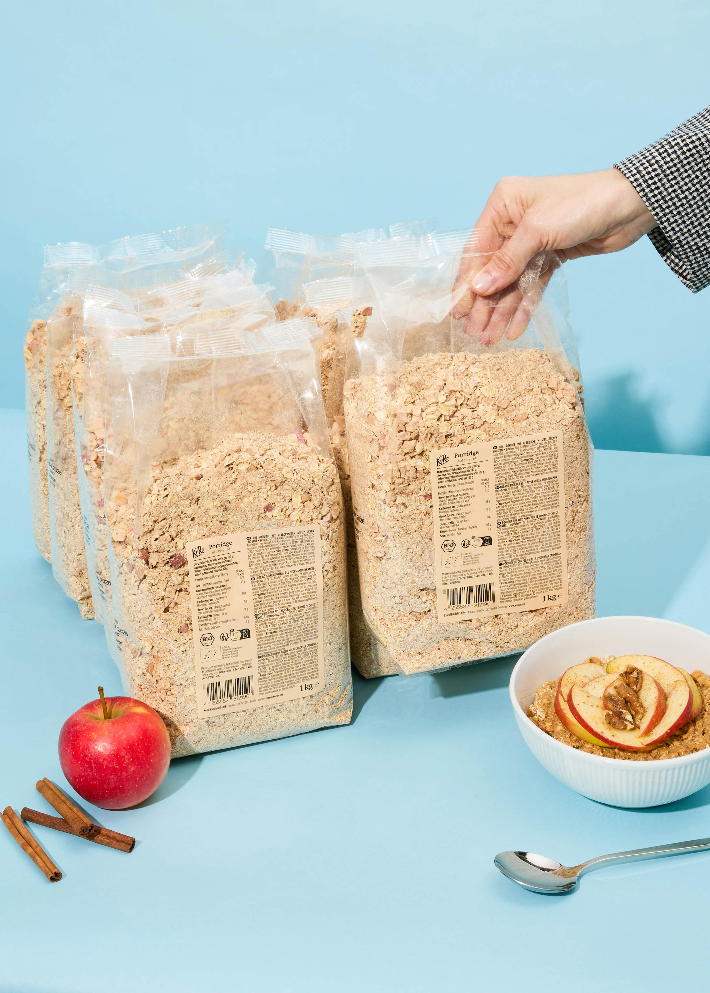 eine Person greift nach einem Paket Haferflocken