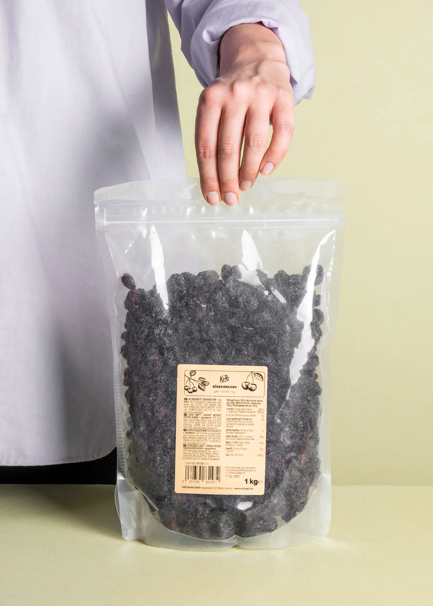 une personne tient un sac en plastique de raisins noirs