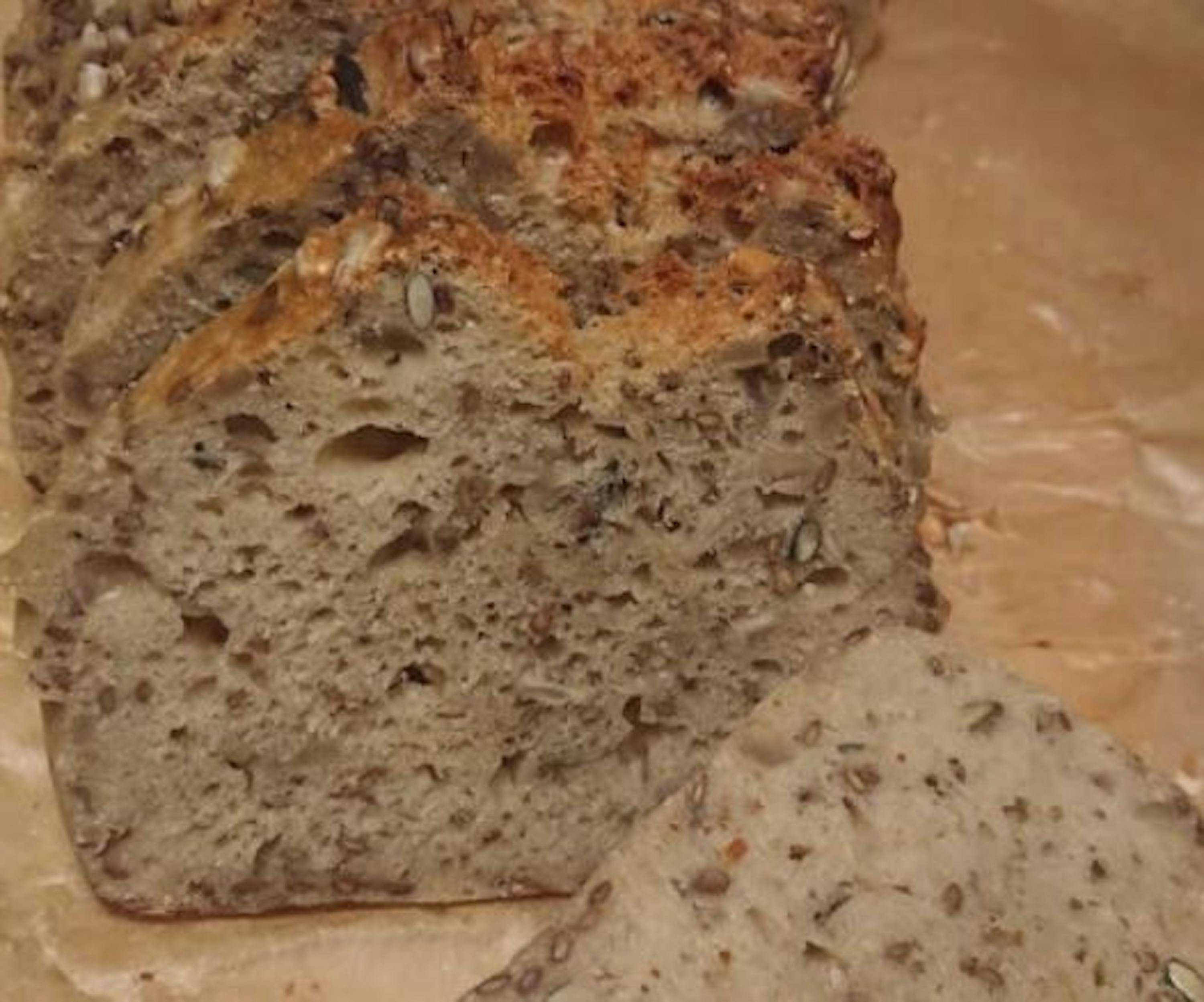 a loaf of bread is sitting on a table next to a slice of bread .