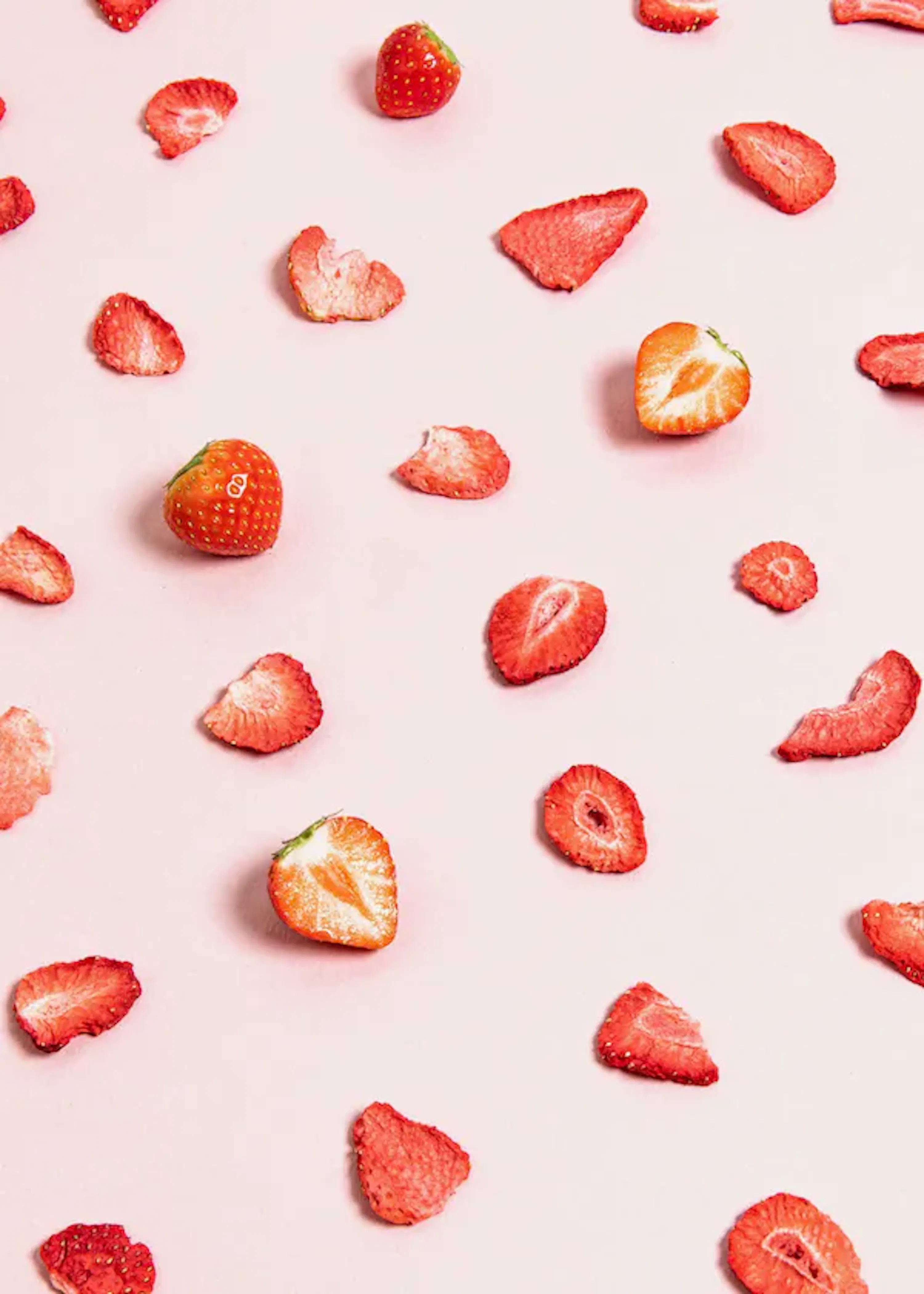 a pattern of dried strawberries on a pink background .