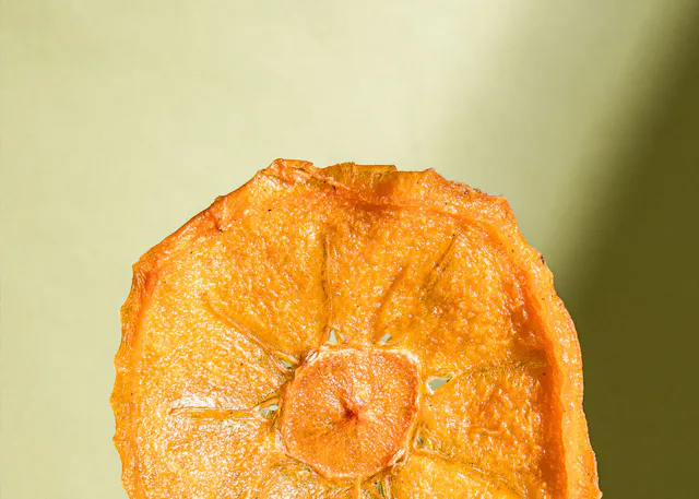 eine Nahaufnahme einer geschnittenen Orange auf einem grünen Hintergrund