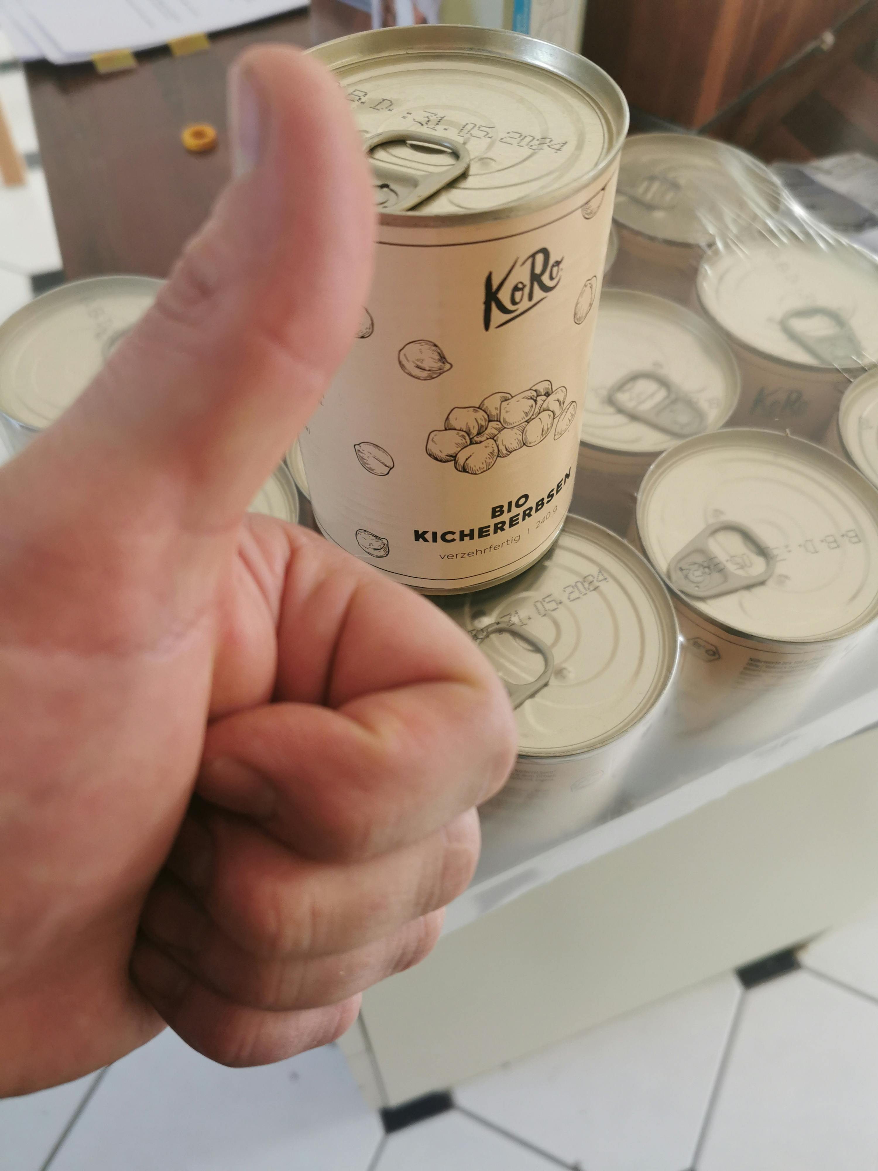 a hand giving a thumbs up next to a can of kichererbsen