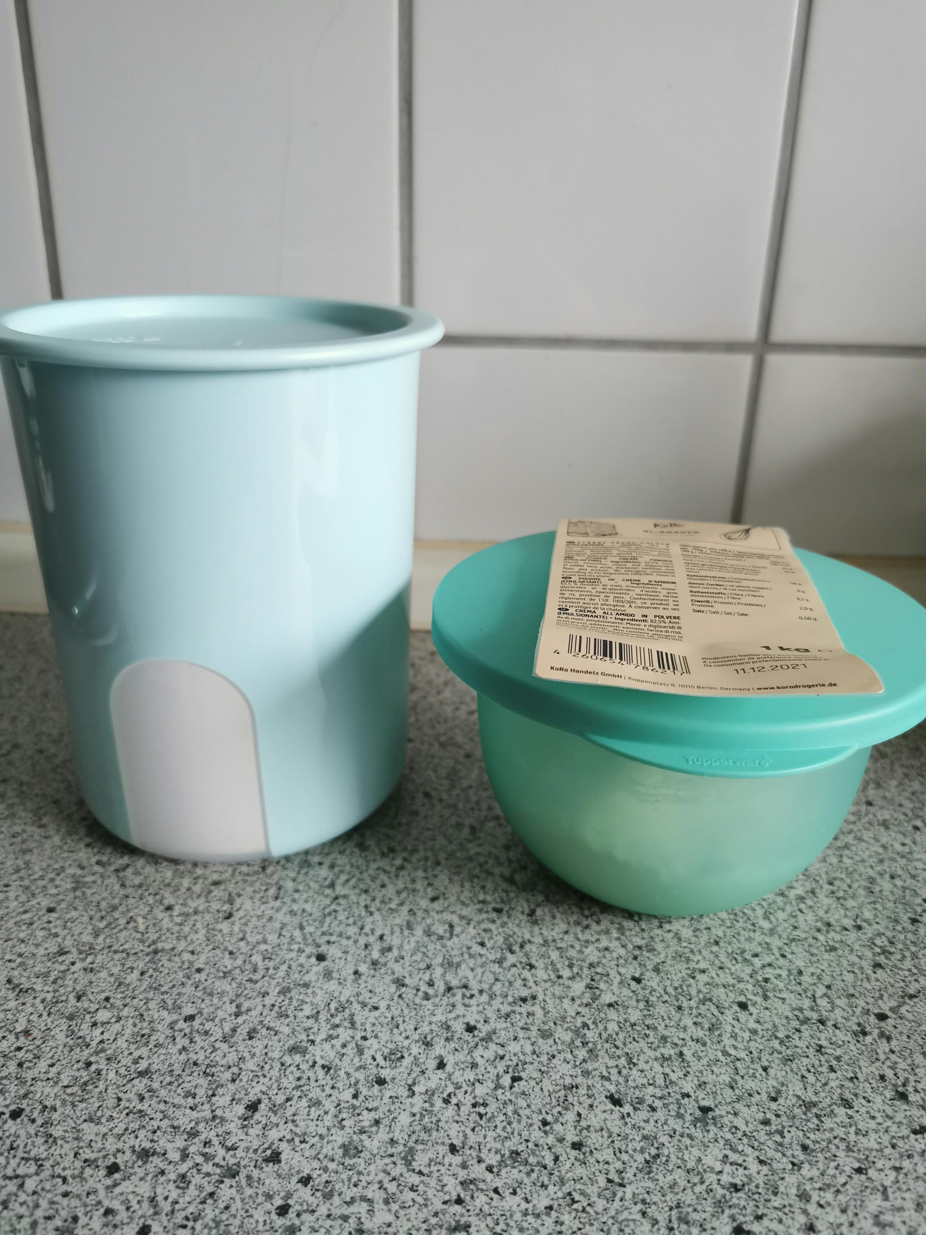un bol bleu et un pot blanc sont posés sur une table