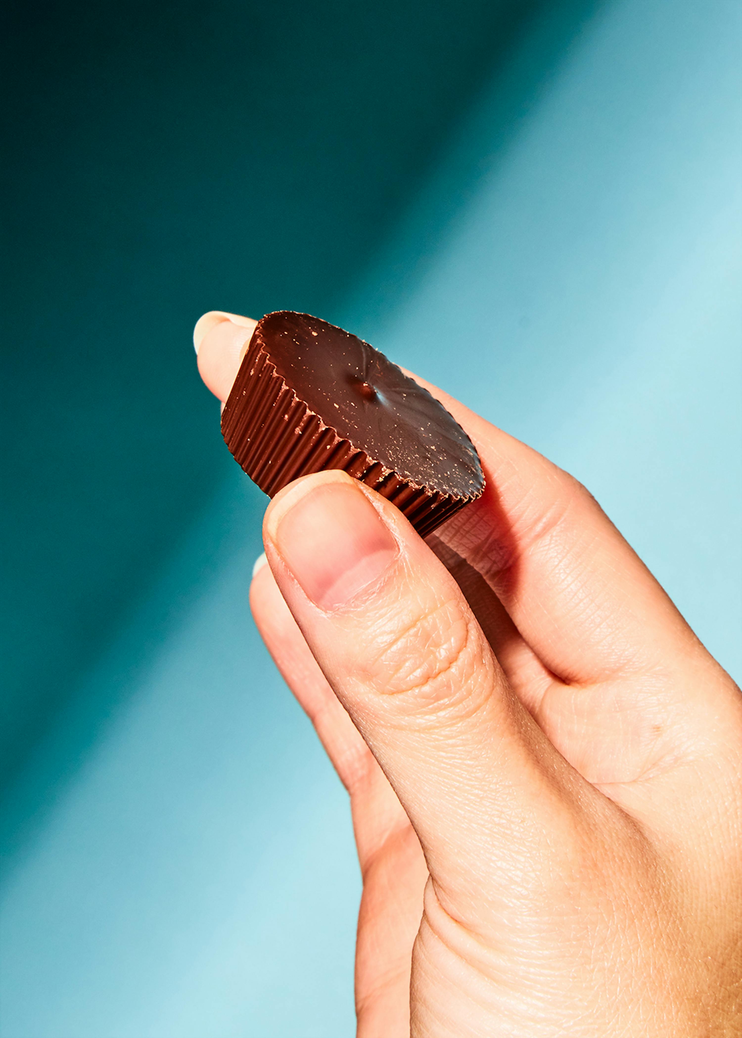 a close up of a person holding a chocolate cup