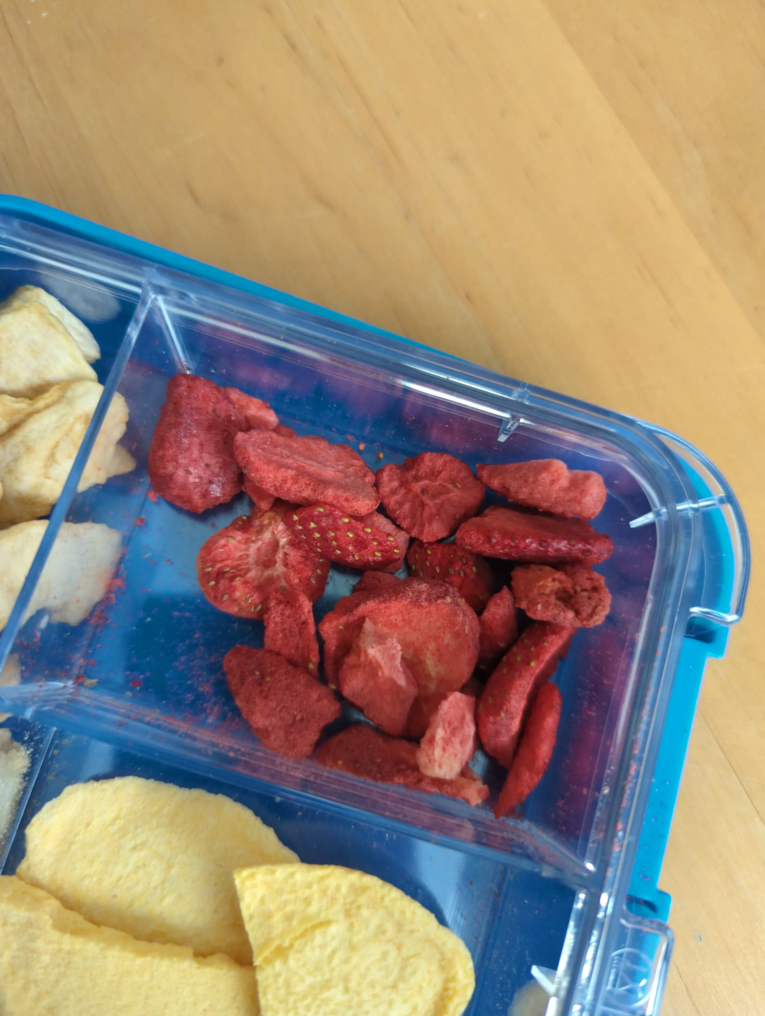 a plastic container filled with dried strawberries and apple chips